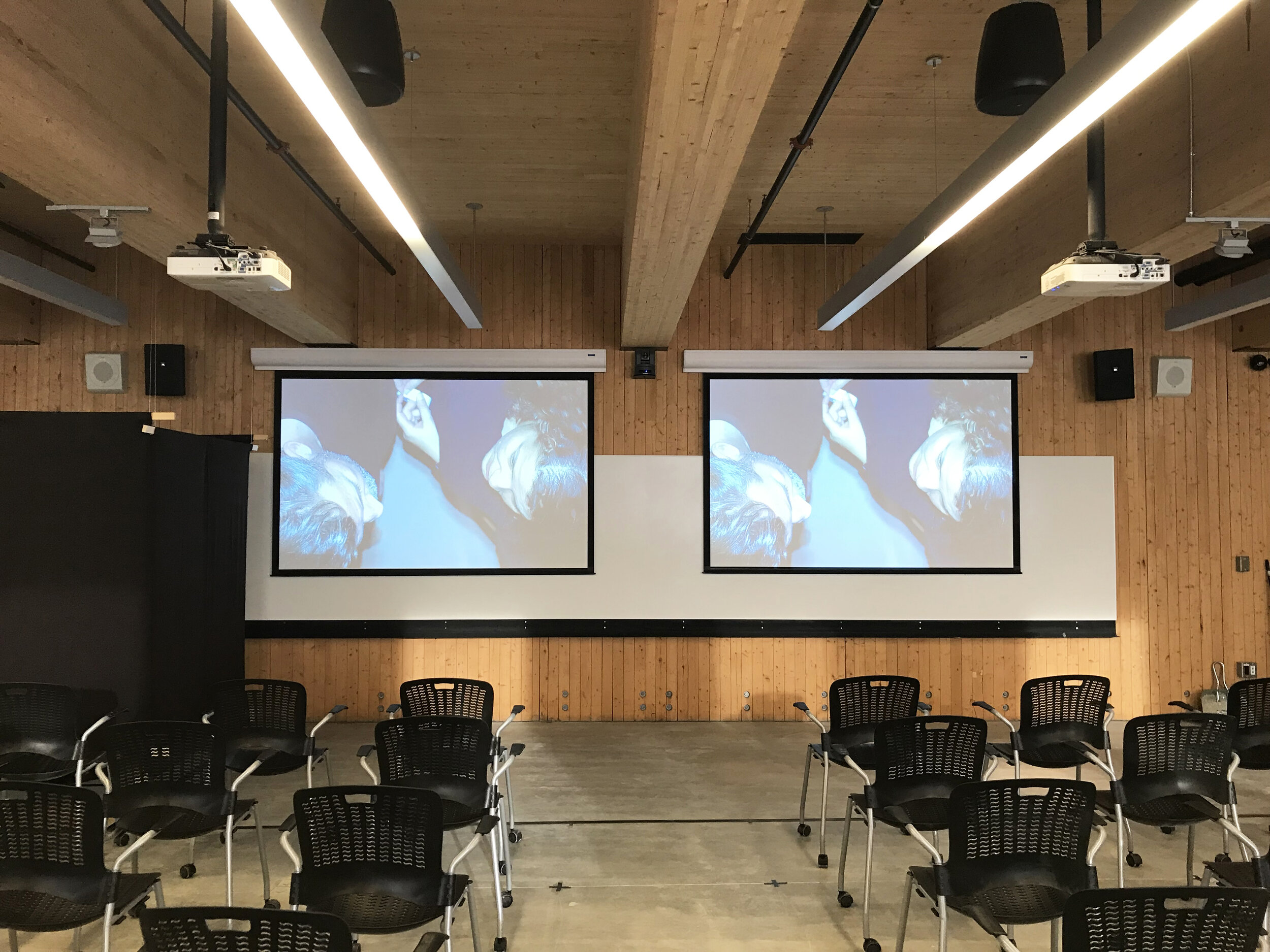  During set-up, the authors tested their projection from the constructed black box, appropriating both the space and the technologies of the classroom. In the foreground the imposed ordinance on the floor and the chair arrangement were calibrated to 