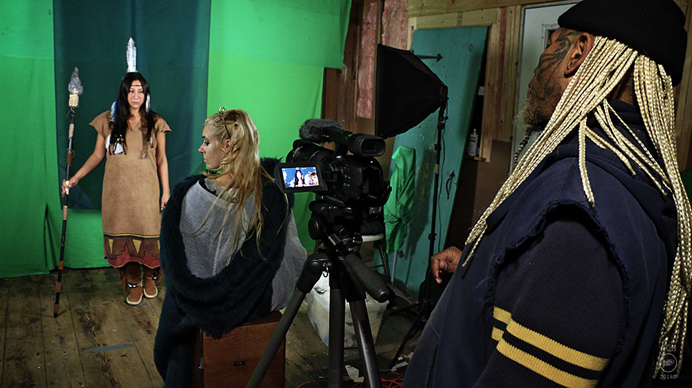 Ahura Z "The Unicorn" directing his sci-fi film Falcyyr- he has cast the women in his life as goddesses who save the world from an alien race. Here he is shooting a green screen scene in his garage- which also serves as the gym where the actors tra