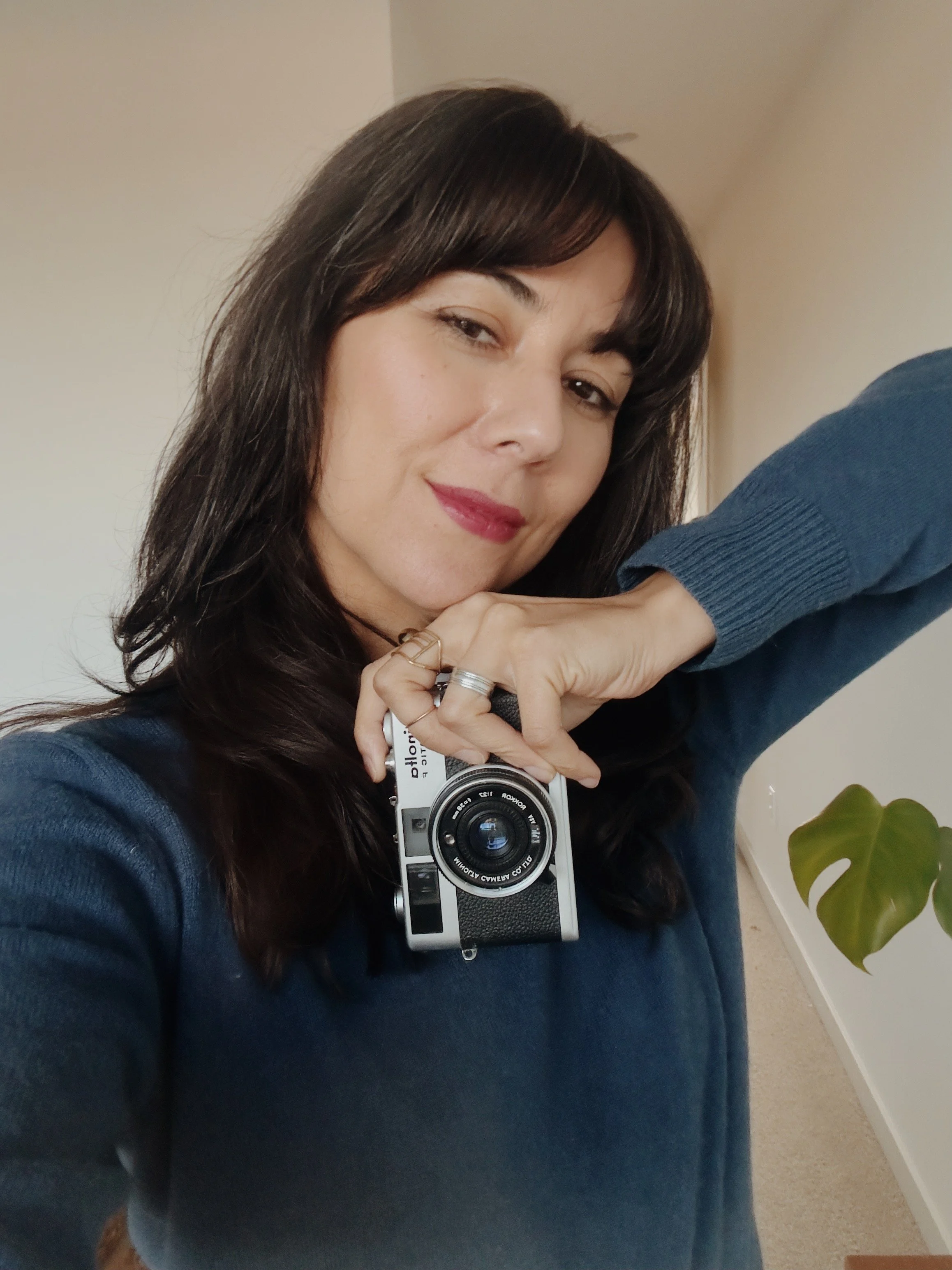 Brown haired woman holding minolta film camera wearing red lipstick-in-seattle-washington