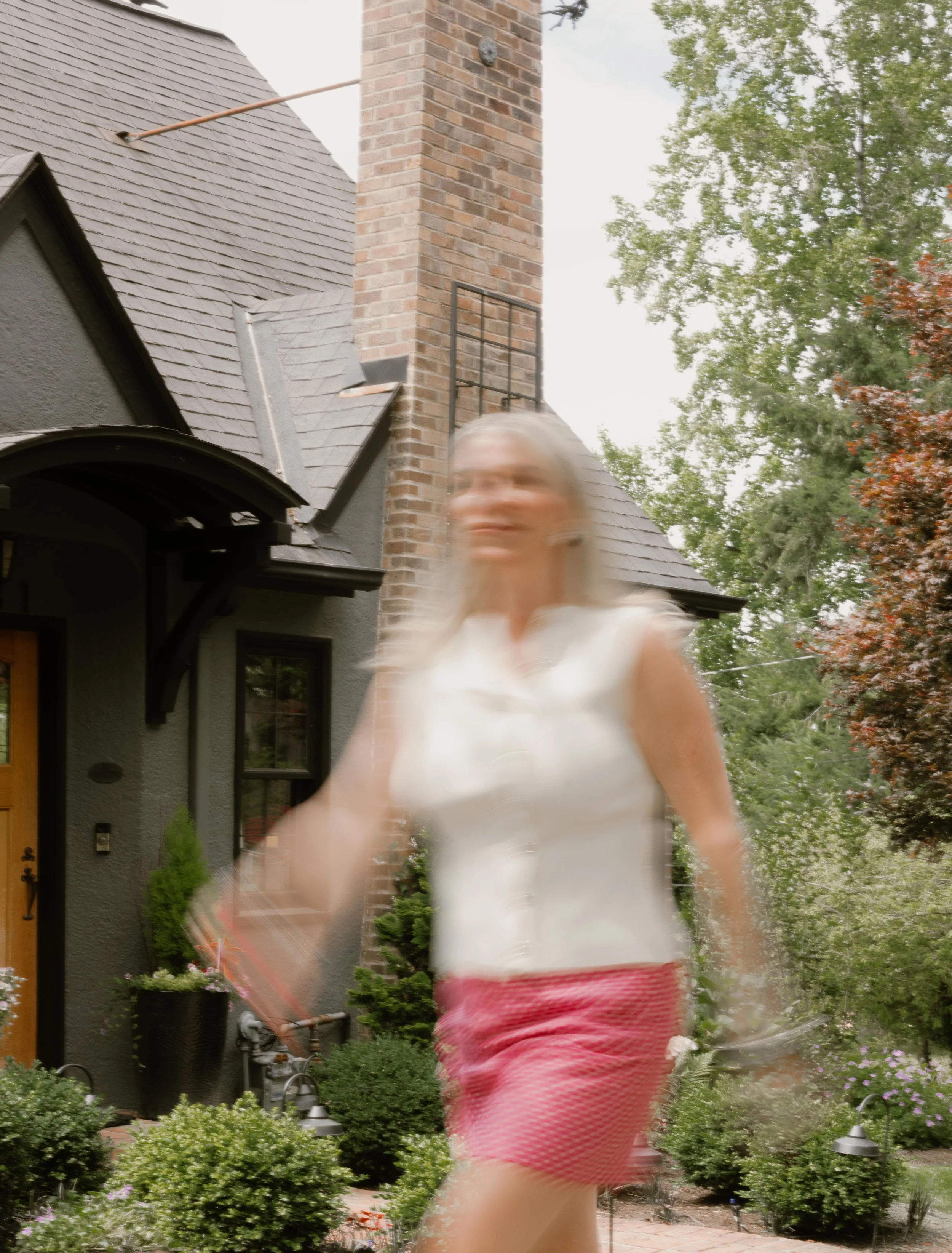 blurry photo of blonde woman walking in front of house in seattle washington
