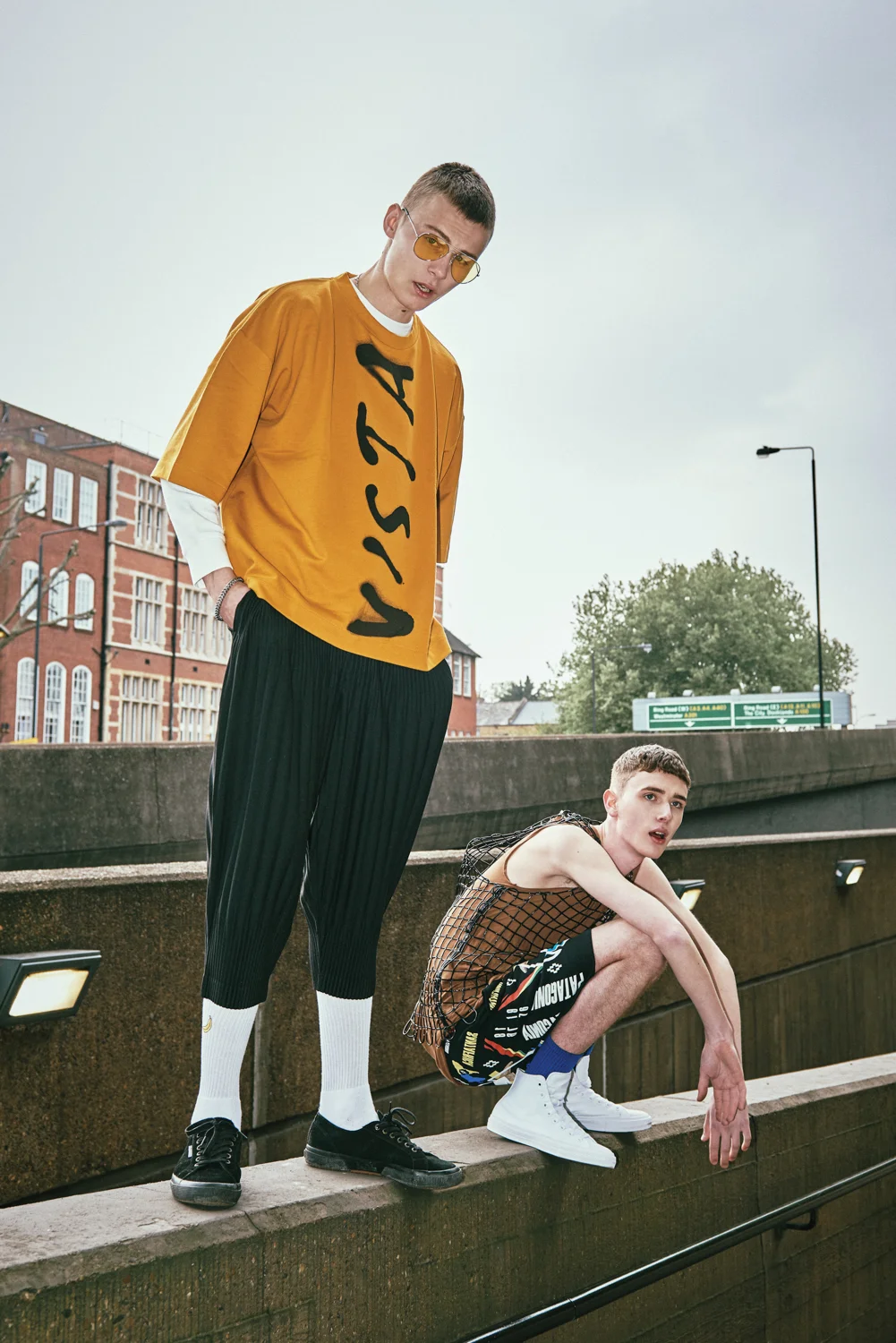 Left Model: T-shirt - ÉTUDES, Long sleeve T-shirt - H&M, Trouser - Issey miyake homme plisse, Socks - Topman, Shoes - Superga, Jewellery - Model’s own, Sunglass - Urban Outfitters. Right Model: Sleeveless T-shirt - Rick Owens, Sleeveless rubber vest - Comme Des Garcons, Short Pants - Marcelo Burlon, Socks - Topman, Shoes- Converse.