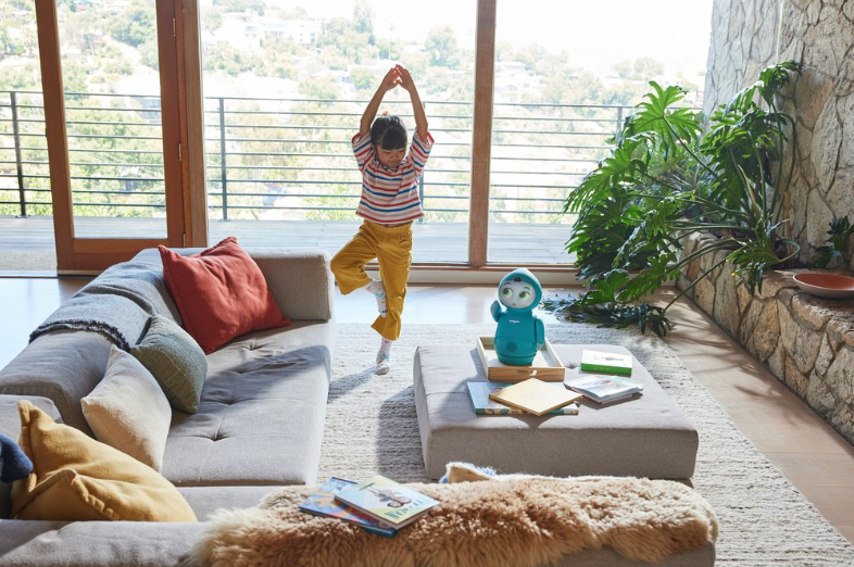 kid doing yoga with robot in living room