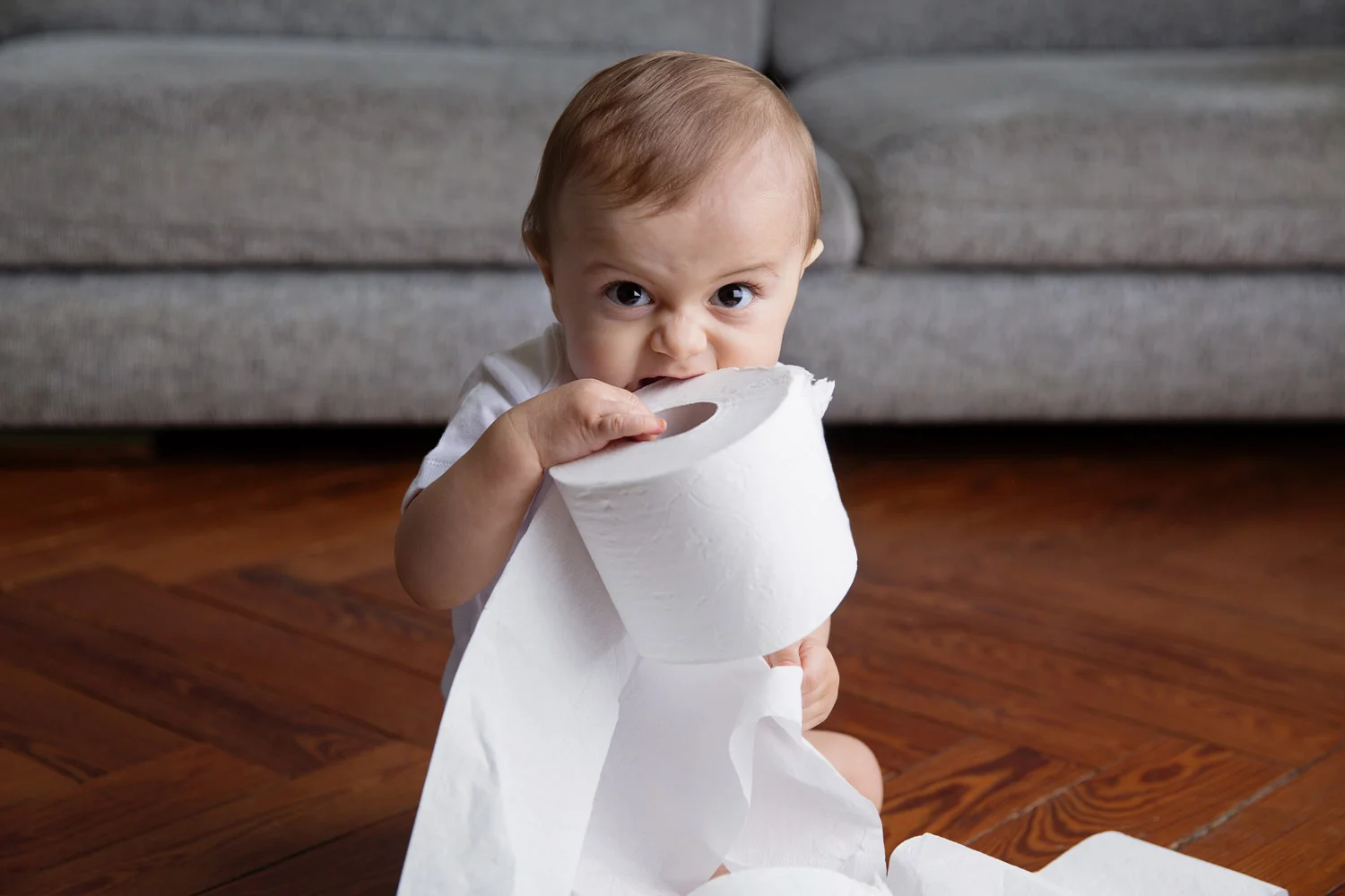 Funny baby biting toilet paper roll by kids commercial photographer Lisa Tichané