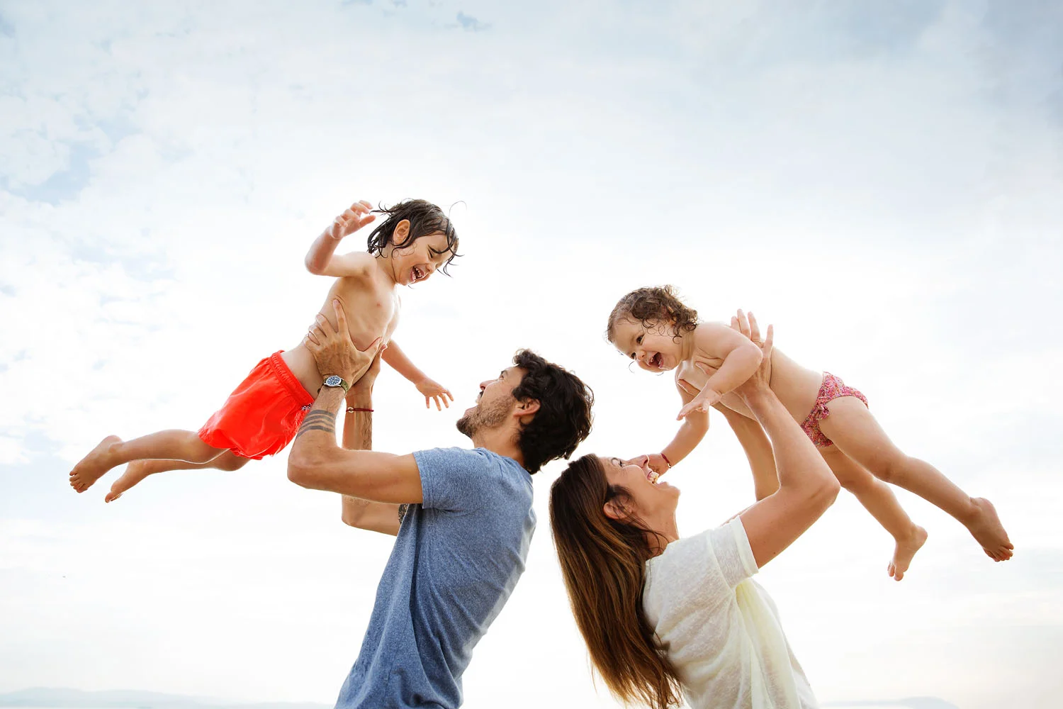 Parents making their children fly in the air by lifestyle advertising photographer Lisa Tichané