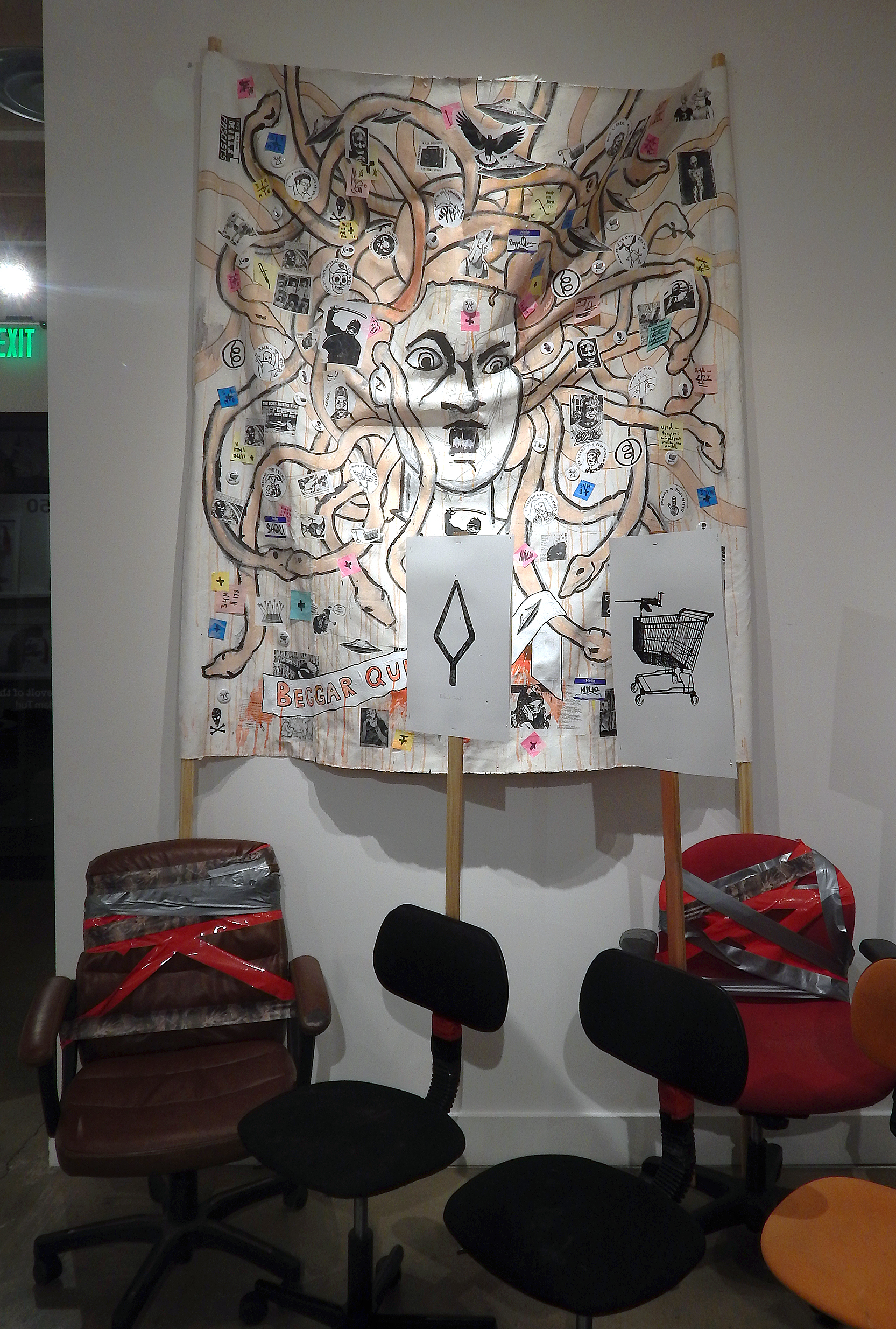 Beggar Queen. Acrylic, stickers, marker, photocopies, buttons, post-it notes, coffee and mixed media on canvas banner with poles (installation view). (2017-2018) (Adam Turl)