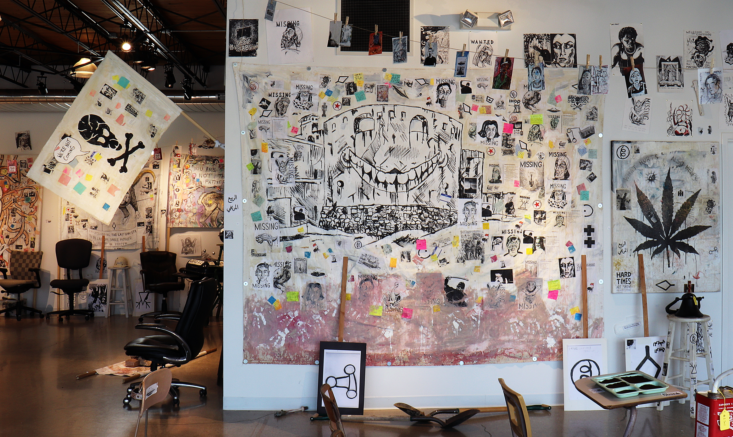 Ohio Erasure Castle. Acrylic, marker, Sharpie, clay slip, photocopies, stickers, post-it notes, coffee and mixed media on canvas tarp.Also in foreground, What Hurts Also Helps (left) and Alien Space Pirates Flag (right).
