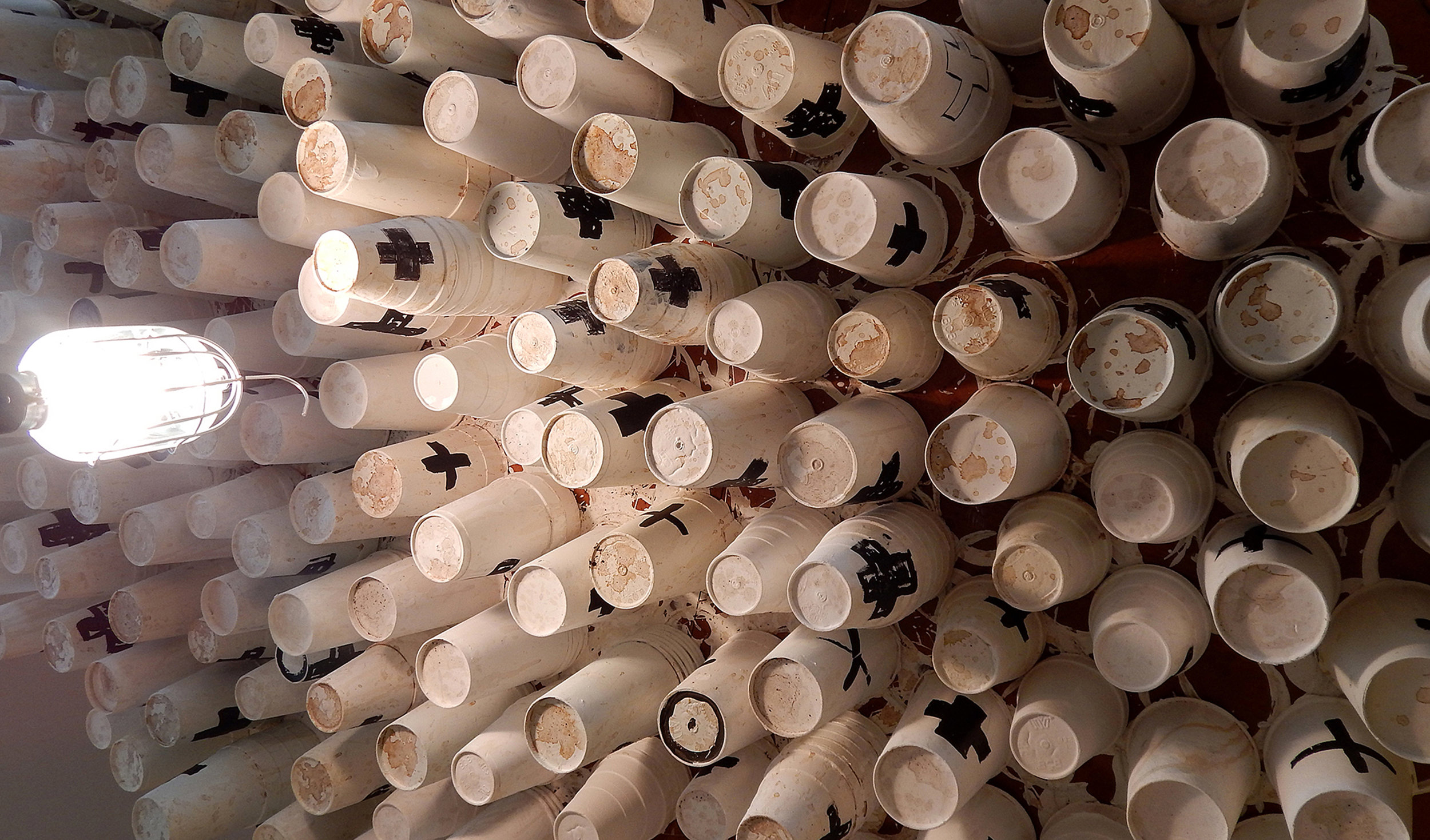 13 Baristas (2015). Acrylic, coffee and gum on canvas with coffee cups, found and sculptural objects, printed newspapers. (Adam Turl)