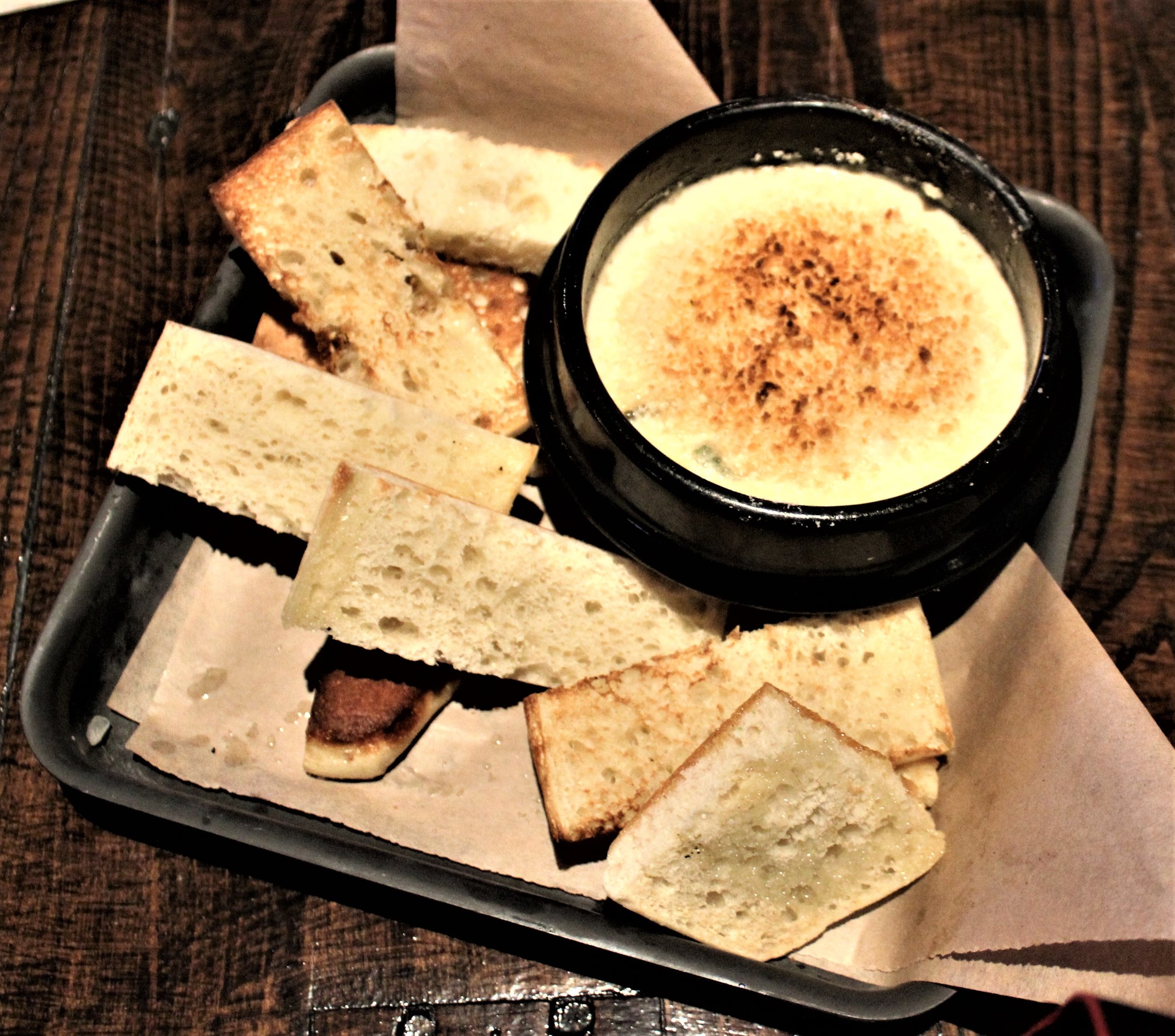 Roasted Crab Dip-This crab dip is served with fire roasted bread. I couldn't keep myself from stuffing my face with this creamy gooey crab filled dip. I can't wait to go back for more.