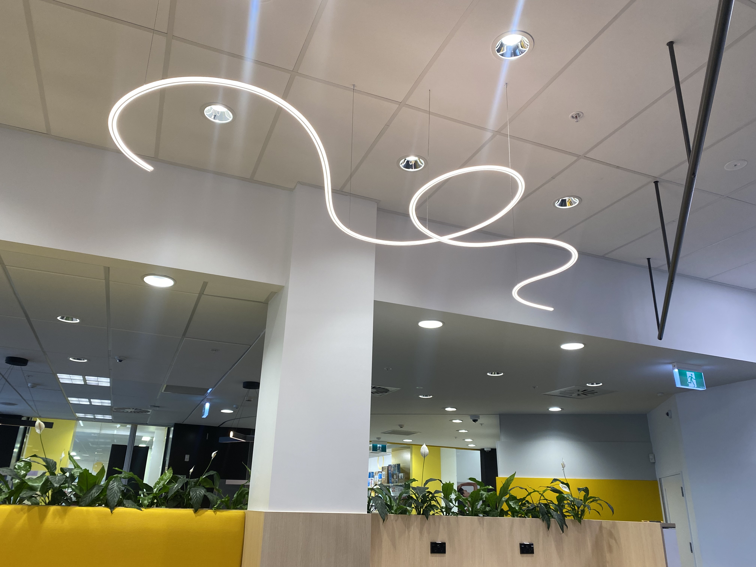 James Russ Sensory Sculpture. Ceiling with modern circular light fixtures and small ceiling vents in a commercial or public space.