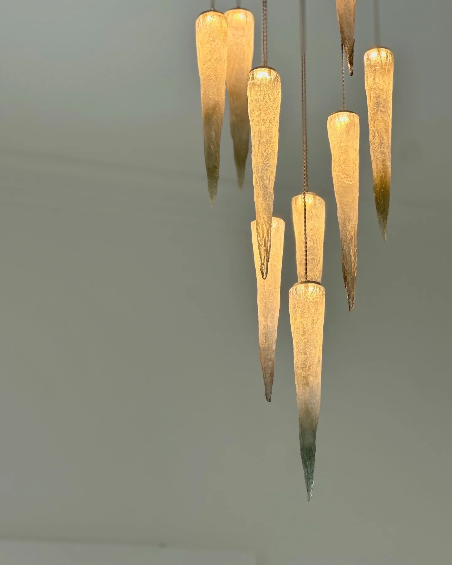 Close-up of a Stalactite chandelier with grey-colored glass icicle-shaped pendants hanging from it.