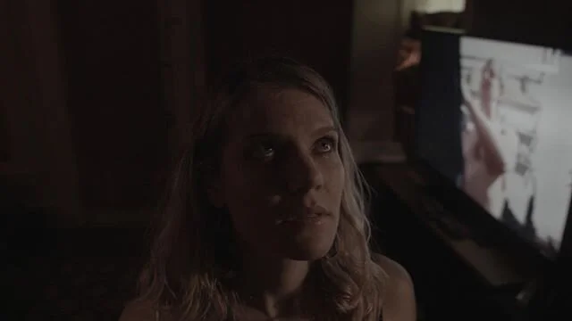 Brandy (Hayley Thirlwall) examines a poster on the wall, not realizing that Levi Anderson in the hit 2013 Southern Oregon film “Creeper” by Ron Huffstutter is revving a chainsaw shirtless on screen behind her. On a related note, Happy bir