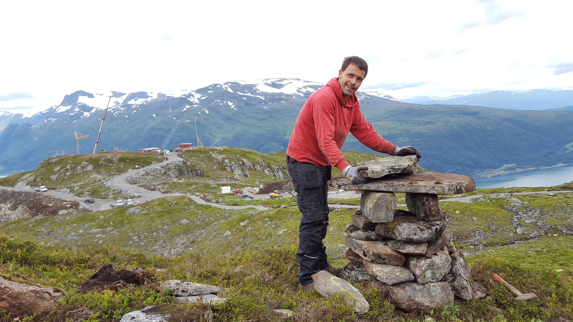 Tradisjonell varding skal vise veg i terrenget, i tillegg til skilting etter nasjonal mal. Rune Holen frå Naturservice legg siste hand på verket på første varden. 