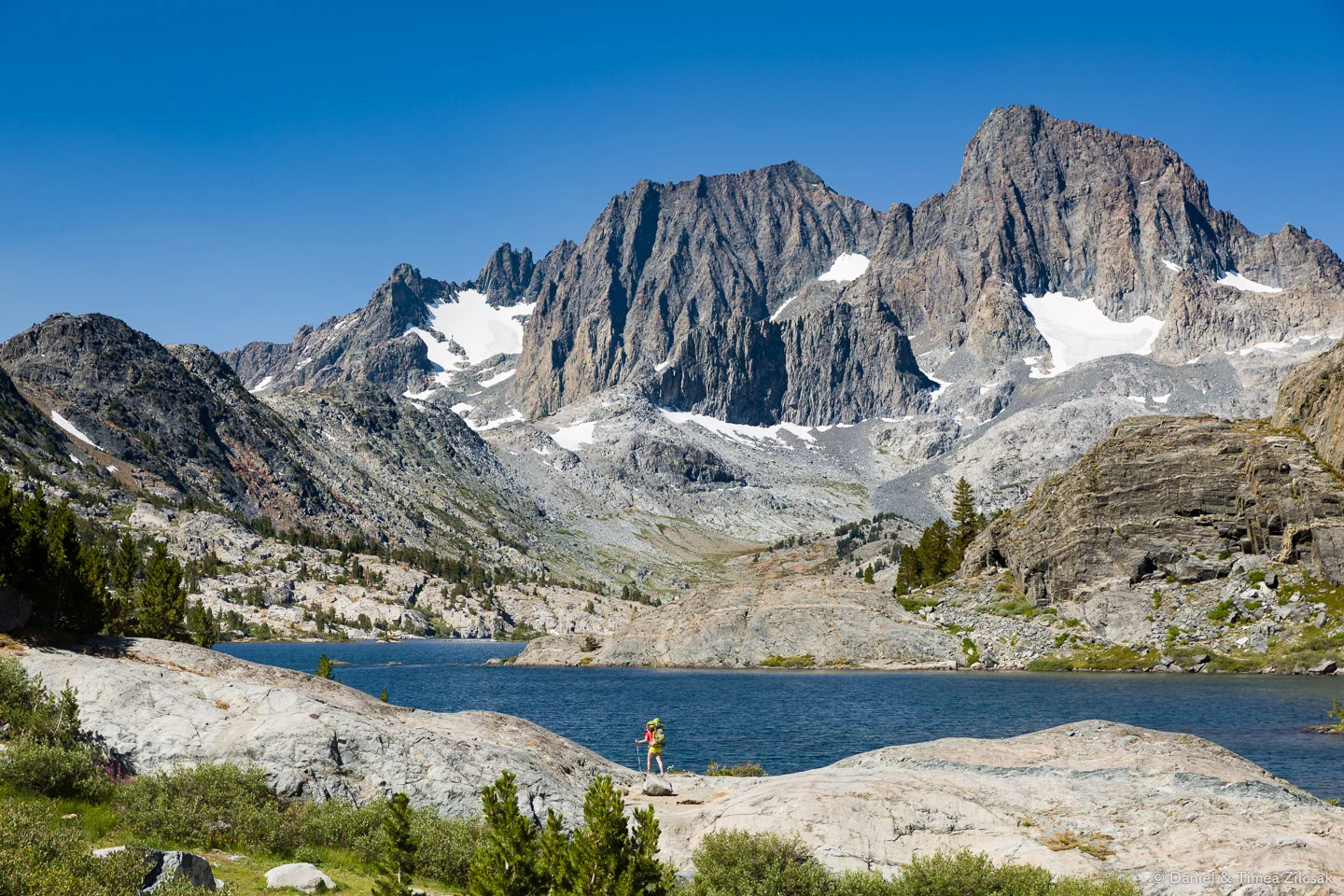 Hiking on the shores of Garnet Lake with Banner Peak across the water