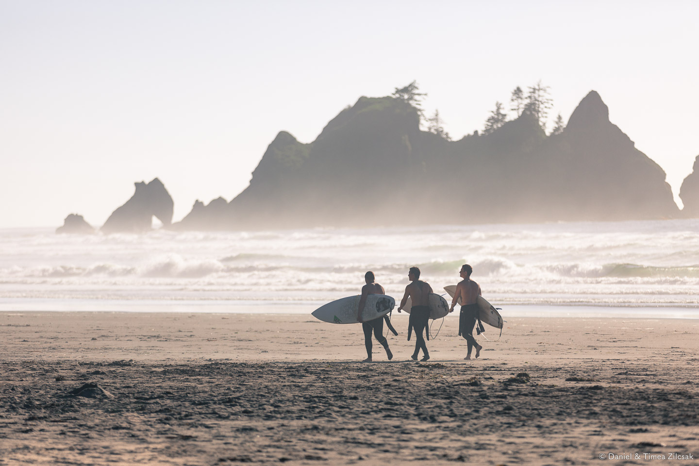 Surfers at Shi Shi Beach with Point of the Arches behind them