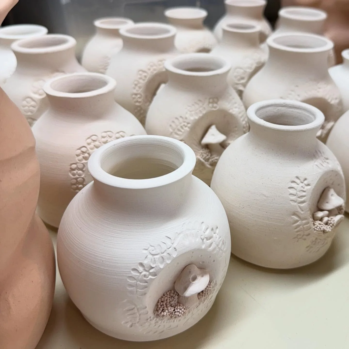 Mushroom vases are on the glazing table this morning, almost ready for their last trip through the kiln!