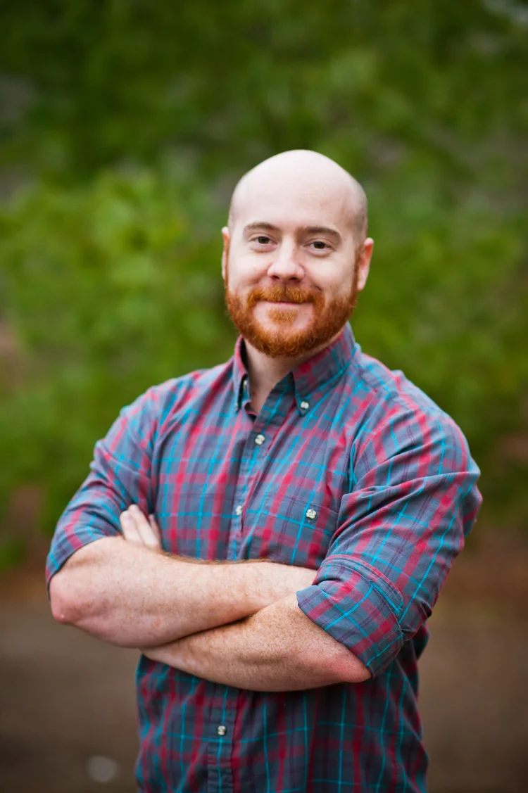 HI I'M JUSTIN!  I am the second shooter for Meagan Sharum Photography during events and weddings. Believe it or not, I had no idea how life changing and important photography would be for me when I started working with my lovely wife. I started out assisting Meagan by carrying her equipment and helping out with lighting - after about 4 years of the best slave labor of my life, I joined her behind the lens.  Luckily, Meg and I have very different shooting styles. She's my little photo sniper, and I'll be the goof on the dance floor tearing it up, and getting those great wide angle shots of you and your guests having the time of their lives.  So where did I start? Theatre. I have over 6 years combined theatrical lighting experience, so it was an easy switch to looking at lighting through a camera. I LOVE deep, dramatic shadows and interesting angles in my photos.  As my wife mentioned, I am a huge gamer. I can nerd it out with the best of them - but trust me, I'm super cool! I also love meeting new people! I'm quite the social butterfly, and I could hold a conversation with a curtain if it would only talk back, haha. I am incredibly blessed to have the opportunity to take photos for a living, and even more so to be able to do it with my bride.