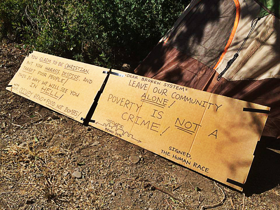The activist camp is set up with a cardboard message for police. Photo provided by Food Not Bombs.
