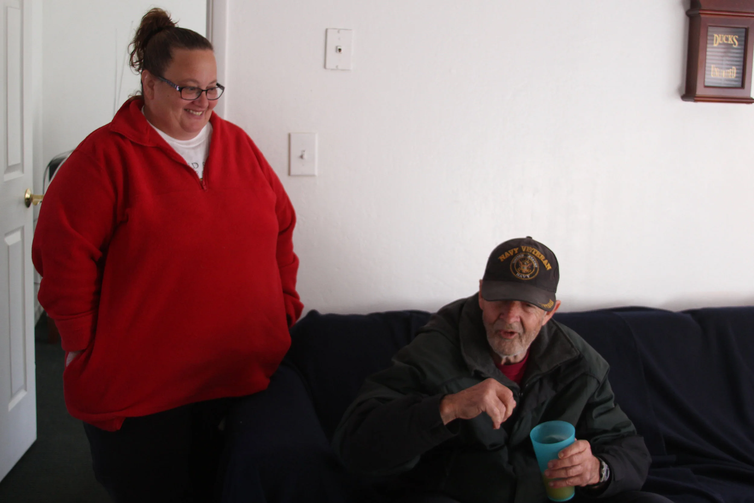 Michelle Mello and Steve, a veteran, share a laugh in the apartment where Doug now lives.