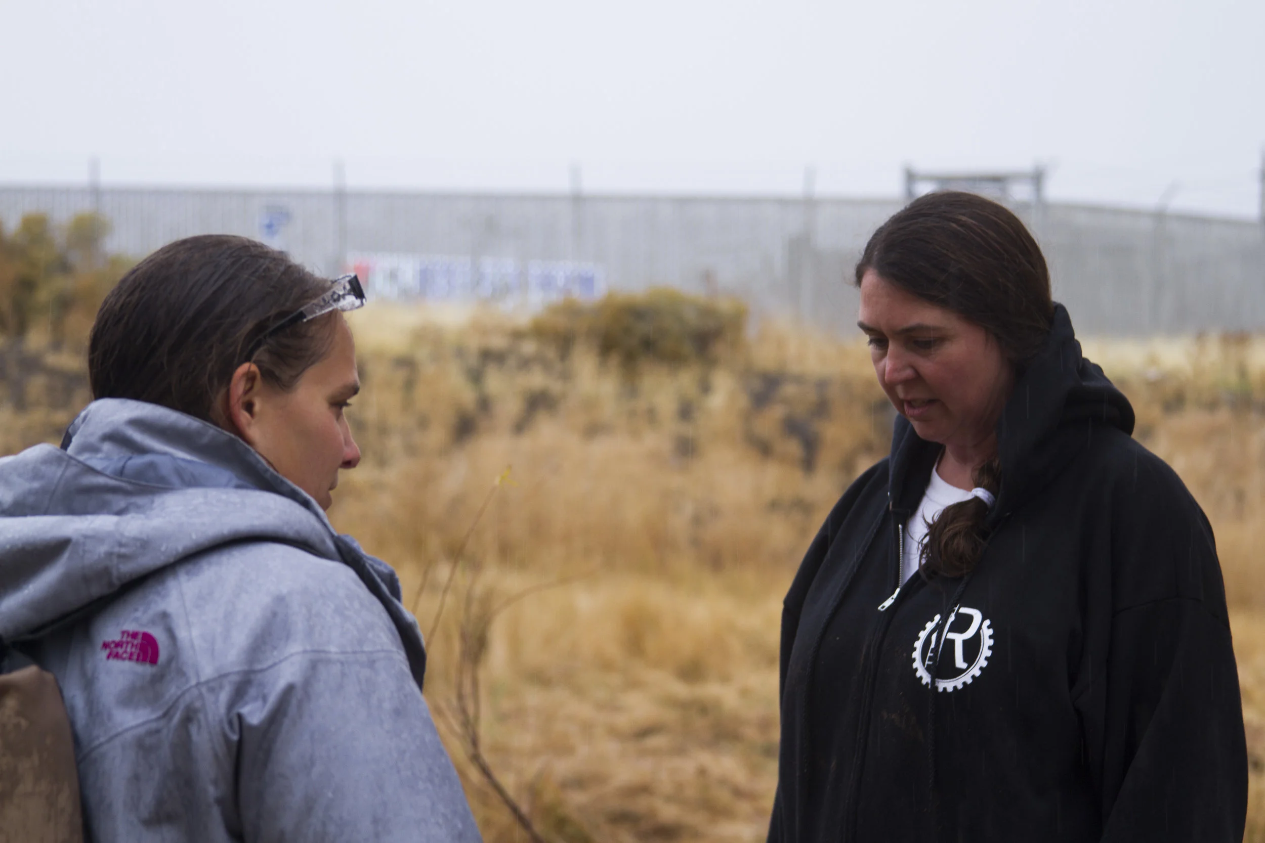 Katie Colling (left) and Jennifer Cassady (right), both with the local Reno group known by its acronym RISE, discuss the homeless encampment area previously protected by brush.