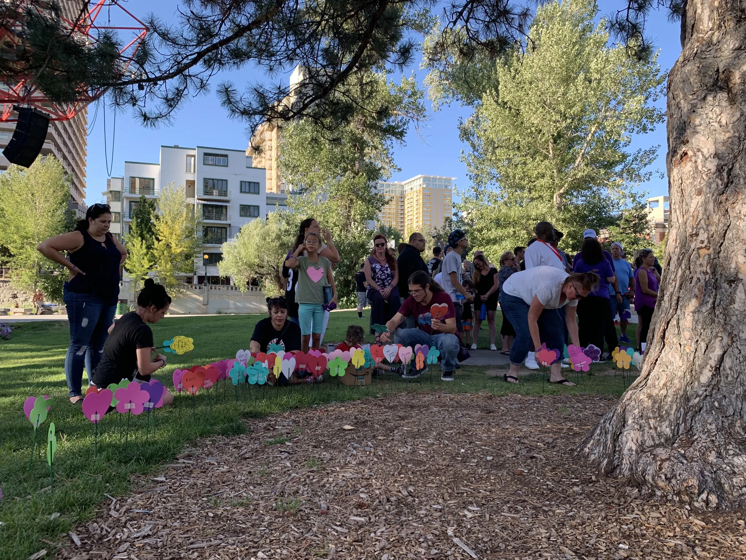 The loving flowers were planted around a tree. People held hands, cried and stood together. Photo by Lucia Starbuck for Our Town Reno.