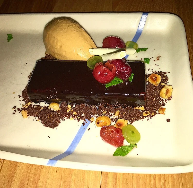 Chocolate cake with roasted grapes, hazelnut and salted caramel gelato