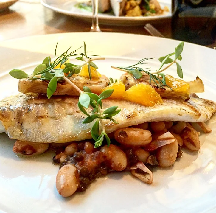 Perfectly cooked sea bass with yellow eye beans, fennel and preserved tomatoes. 