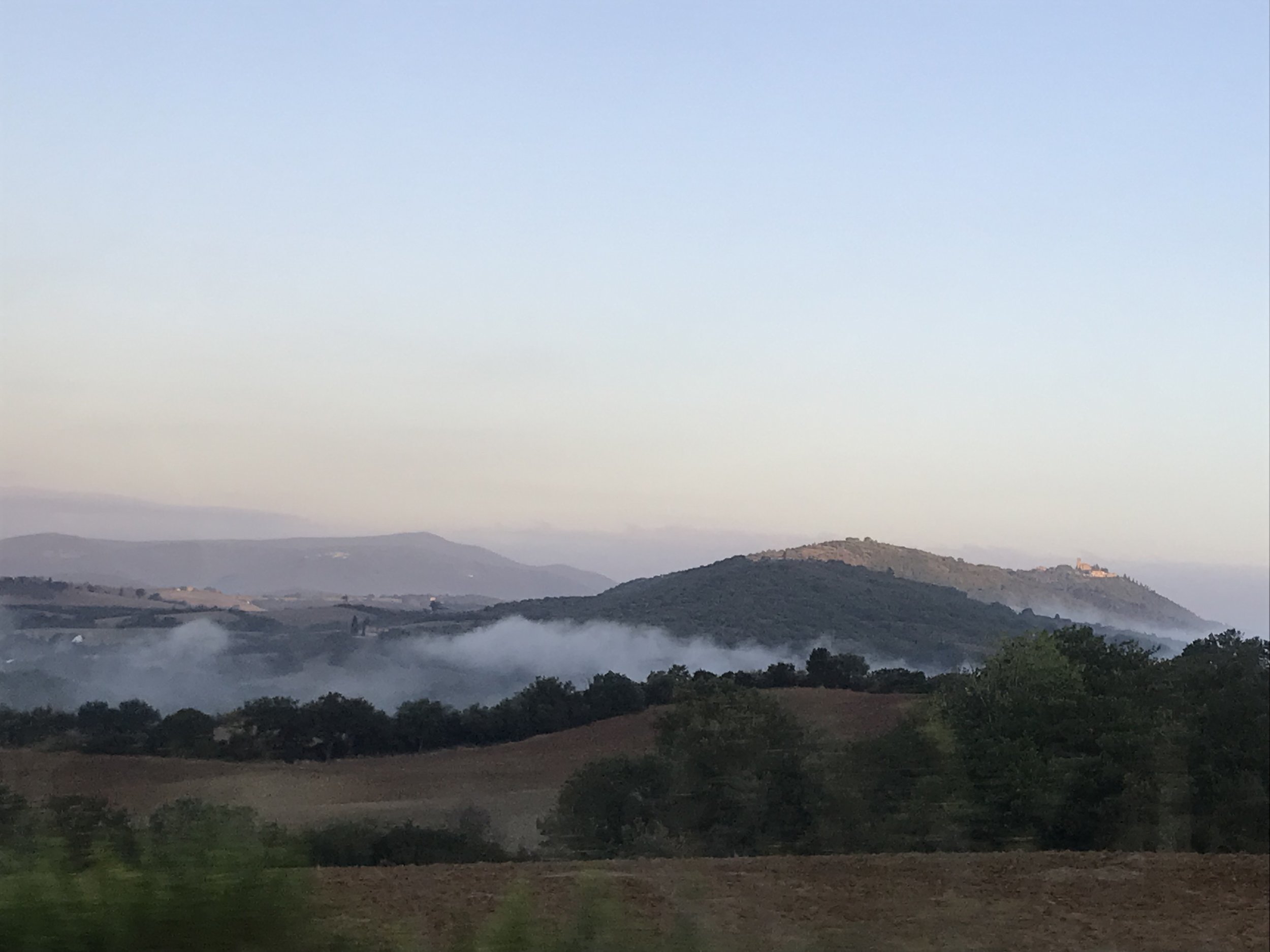 The early morning fog lies in the valleys of Montecucco.