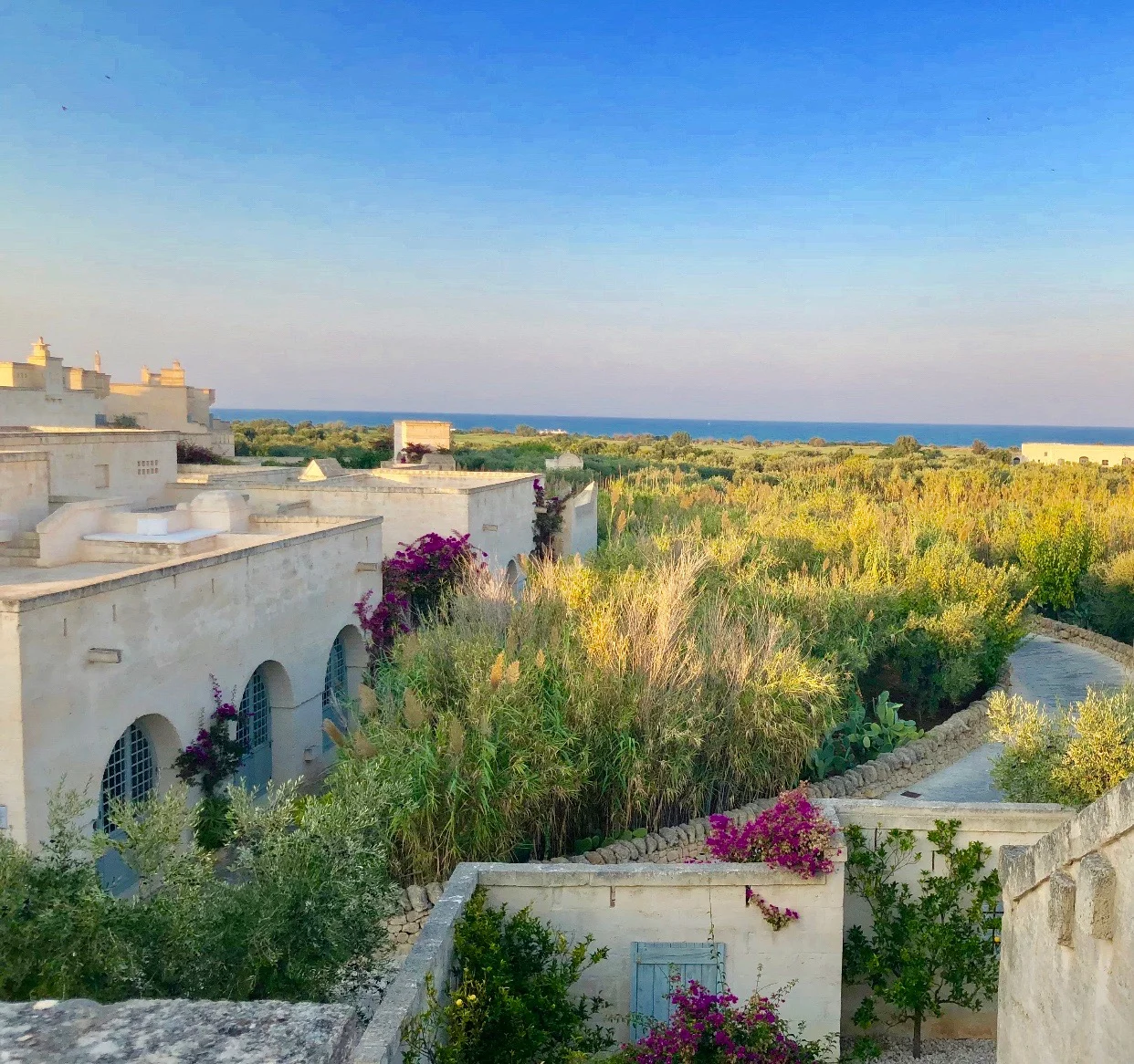 White stone buildings overlooking the Vivid blue Salento sky and sea.