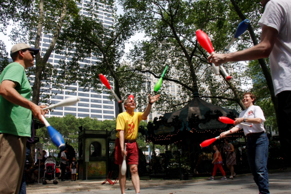 A juggling instructor, left, facilitates a group juggle session in Bryant Park, NYC.