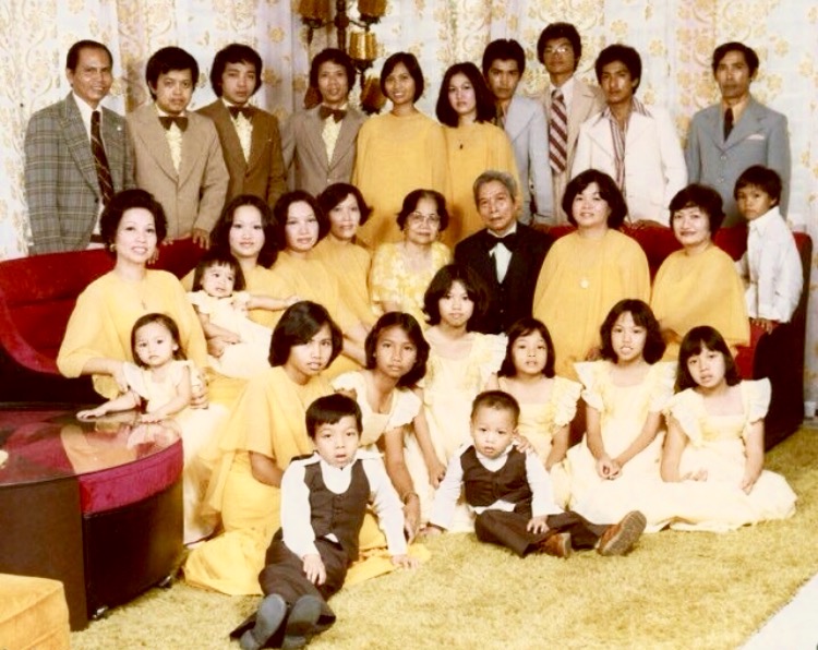 Papa (standing far left, checkered jacket) / Mama (seated far left with my youngest sister Ricci) / Ate Cheryl (standing fifth from Papa) / Tommy (seated at the couch-arm far right) / MJ and Ces (seated at the floor directly in front of Mama / Lolo & Lola (center) / Uncles and Aunts and Cousins shown / + The only guy with spectacles, afro hairdo, organic beach tan, clown Pierre Cardin tie, and super-high waist slacks: In Search of Identity Me. Early 70's