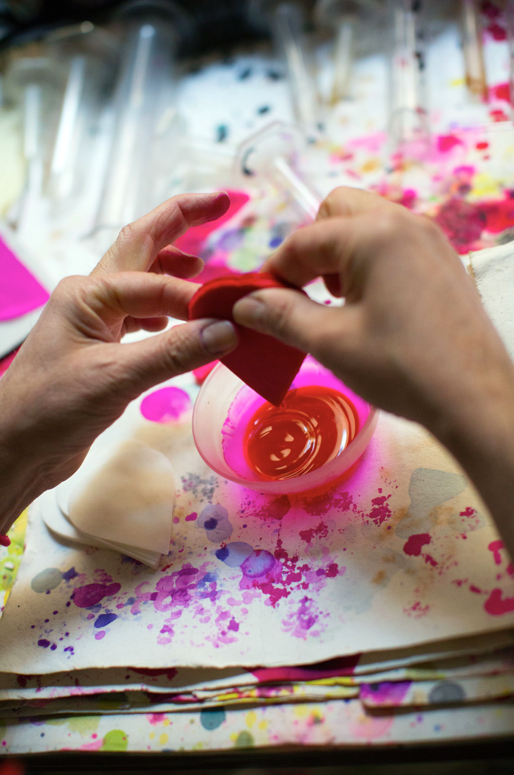  A woman dyes flower petals inside the atelier of Maison Legeron, Paris.  