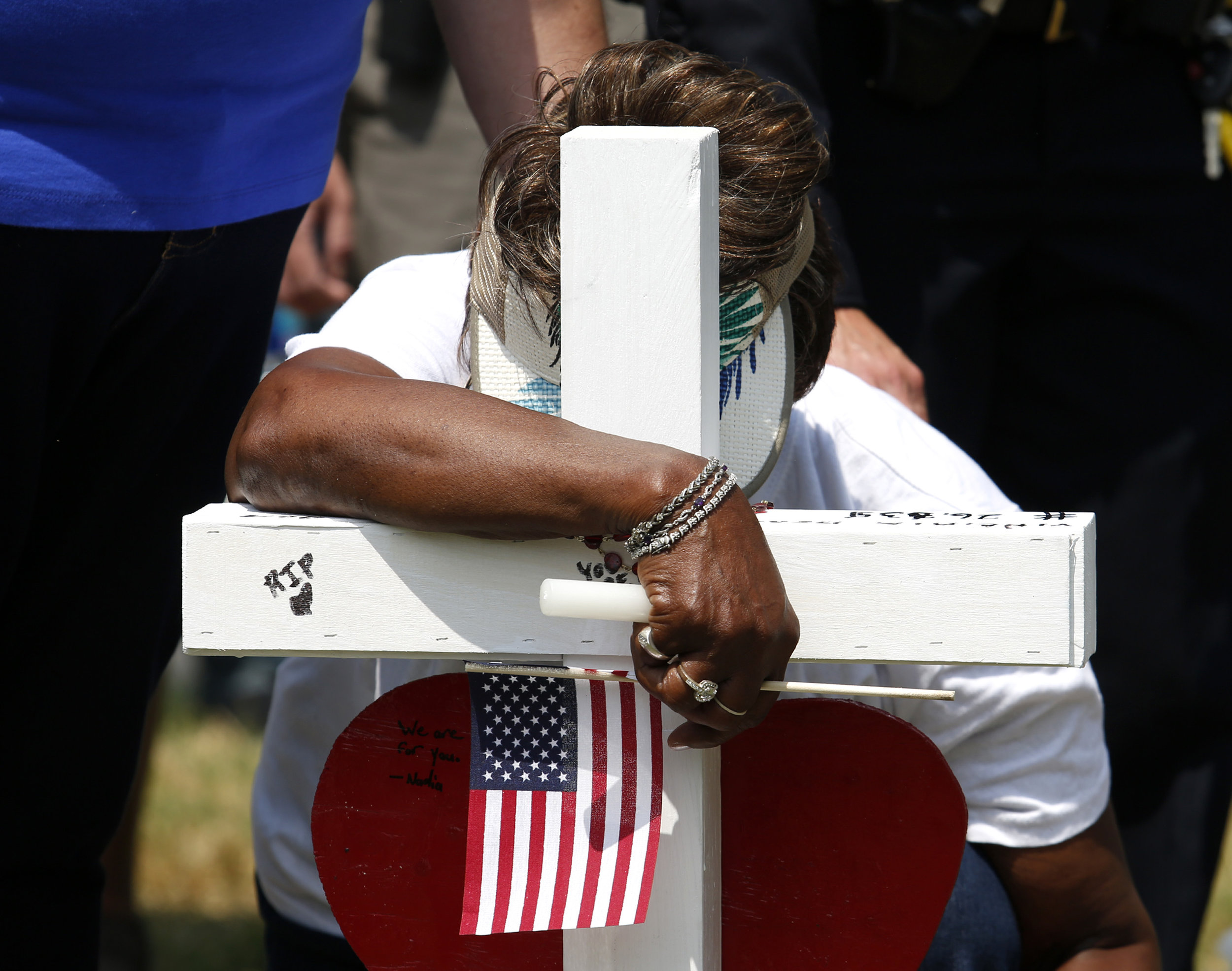  Barbara Penn kneels and rests her head on the cross to honor her niece, LaQuita Brown, at a memorial located by Building 11 of the Virginia Beach Municipal Center on Sunday, June 2, 2019. Brown was killed during a mass shooting that took place at th
