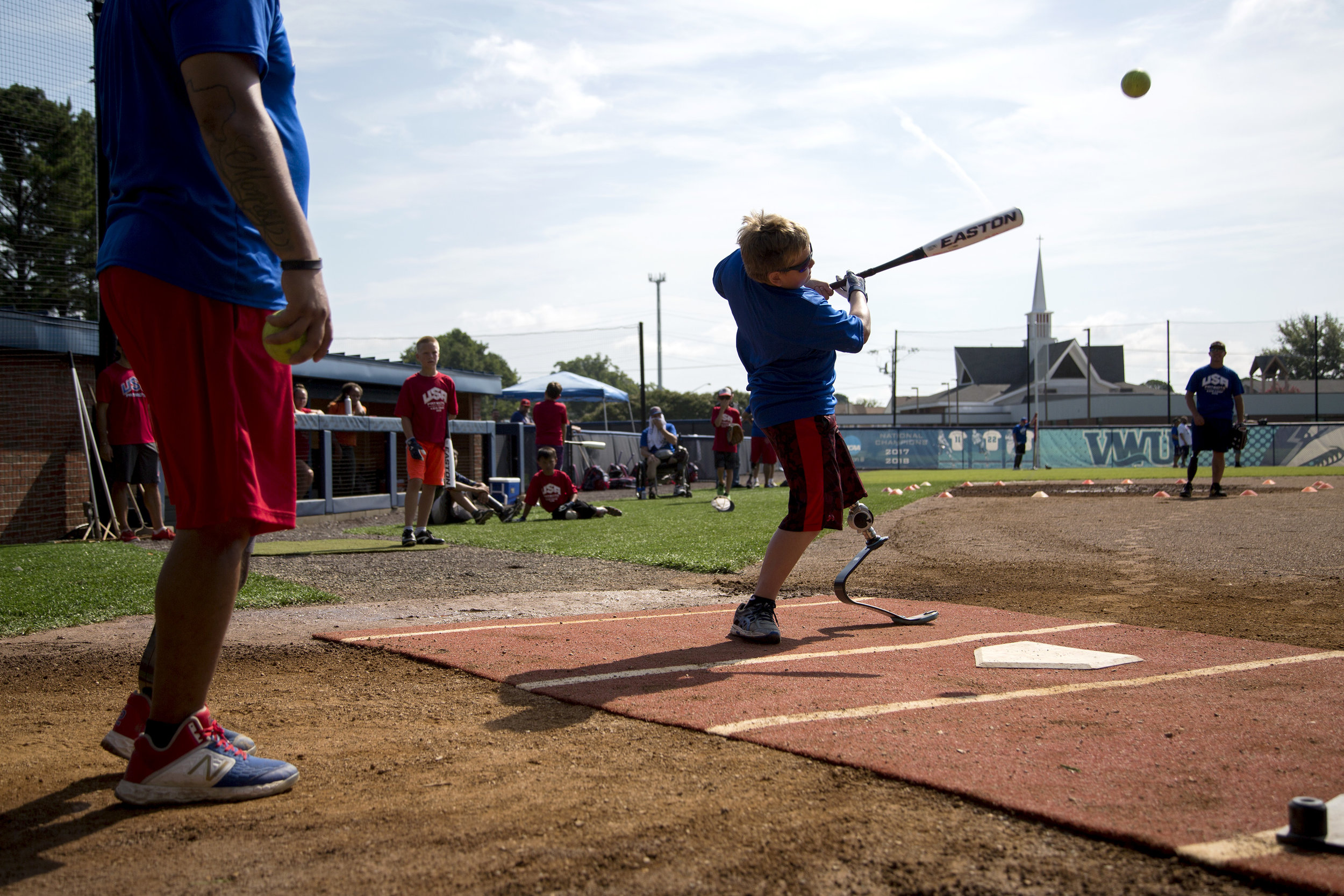  Landon Uthke, 11, from Minnesota, strikes the ball during batting practice during the seventh annual Kids Camp, hosted by the USA Patriots Amputee Softball Team at Virginia Wesleyan University on August 1, 2019. The team has flown in 17 kids, ages 8