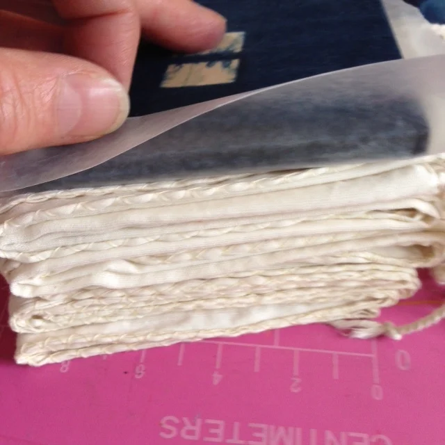 Because I have used my blocks a lot of times, I protect the fabric with a little bit of waxed paper to keep the fabric clean and the lines clear.