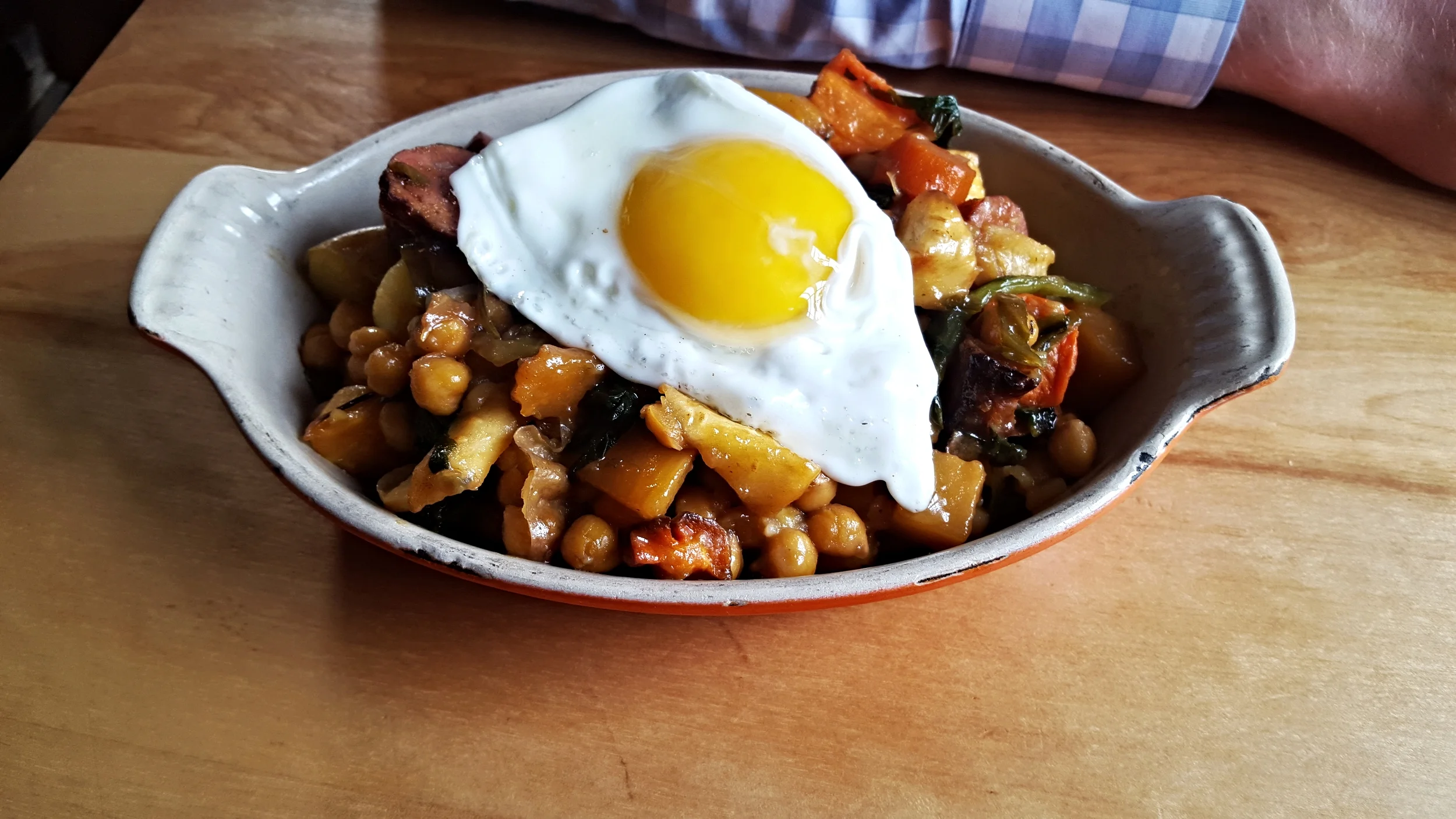 Breakfast Hash - roasted root vegetables, smoked duck sausage, cabbage and an egg sunny-side up.