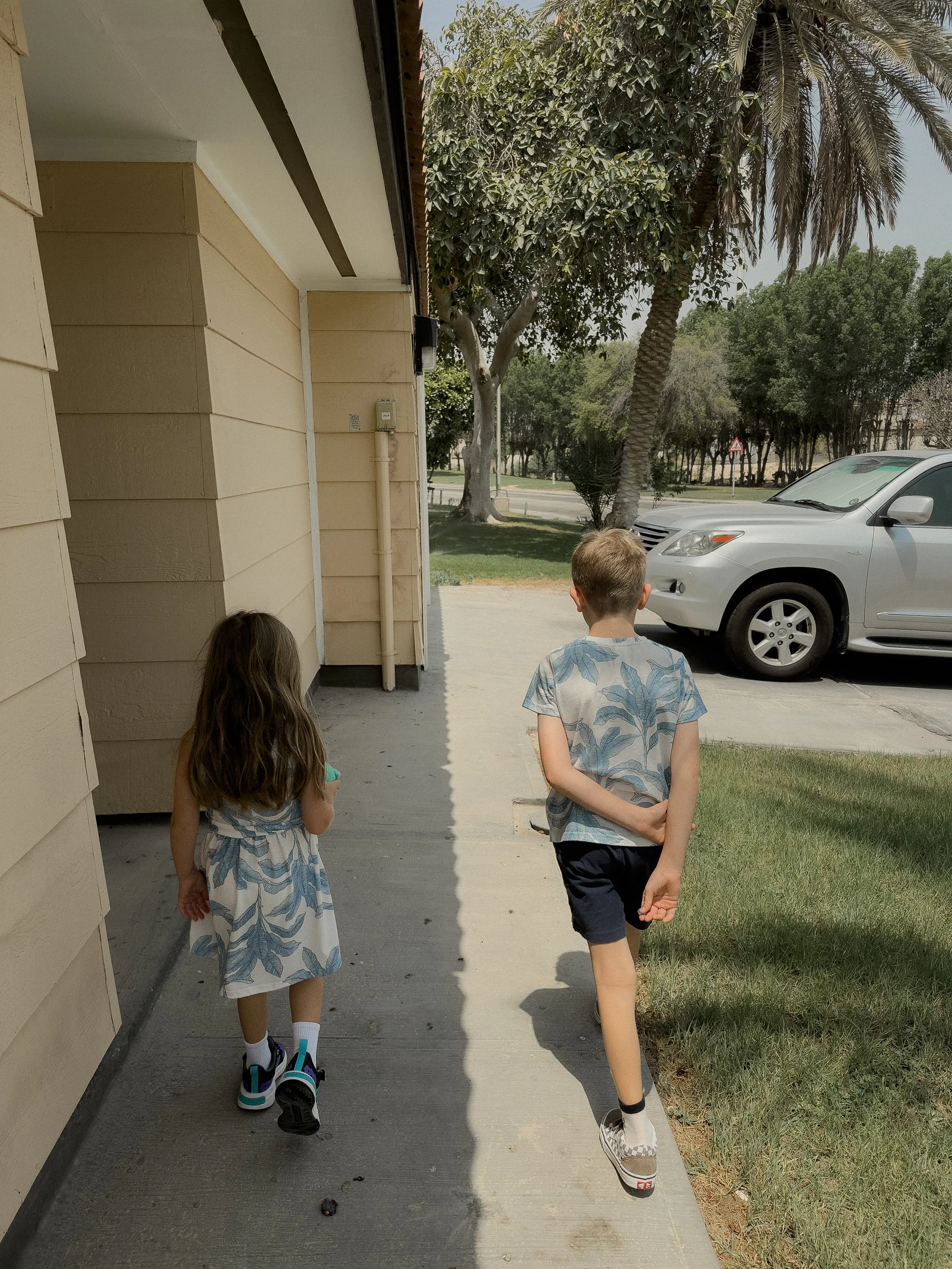 Brother and sister walking to school together in Saudi Arabia.