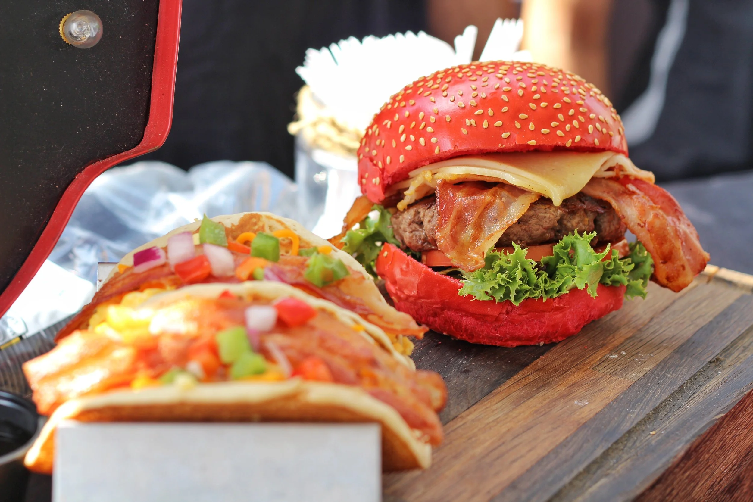 Fluffy buttermilk pancakes stuffed with a combination of fried and scrambled egg, topped with tomato, green pepper, onion and maple bacon strips, drizzled with chipotle syrup + Canada 150 inspired All-Canadian Red Hot Burger.