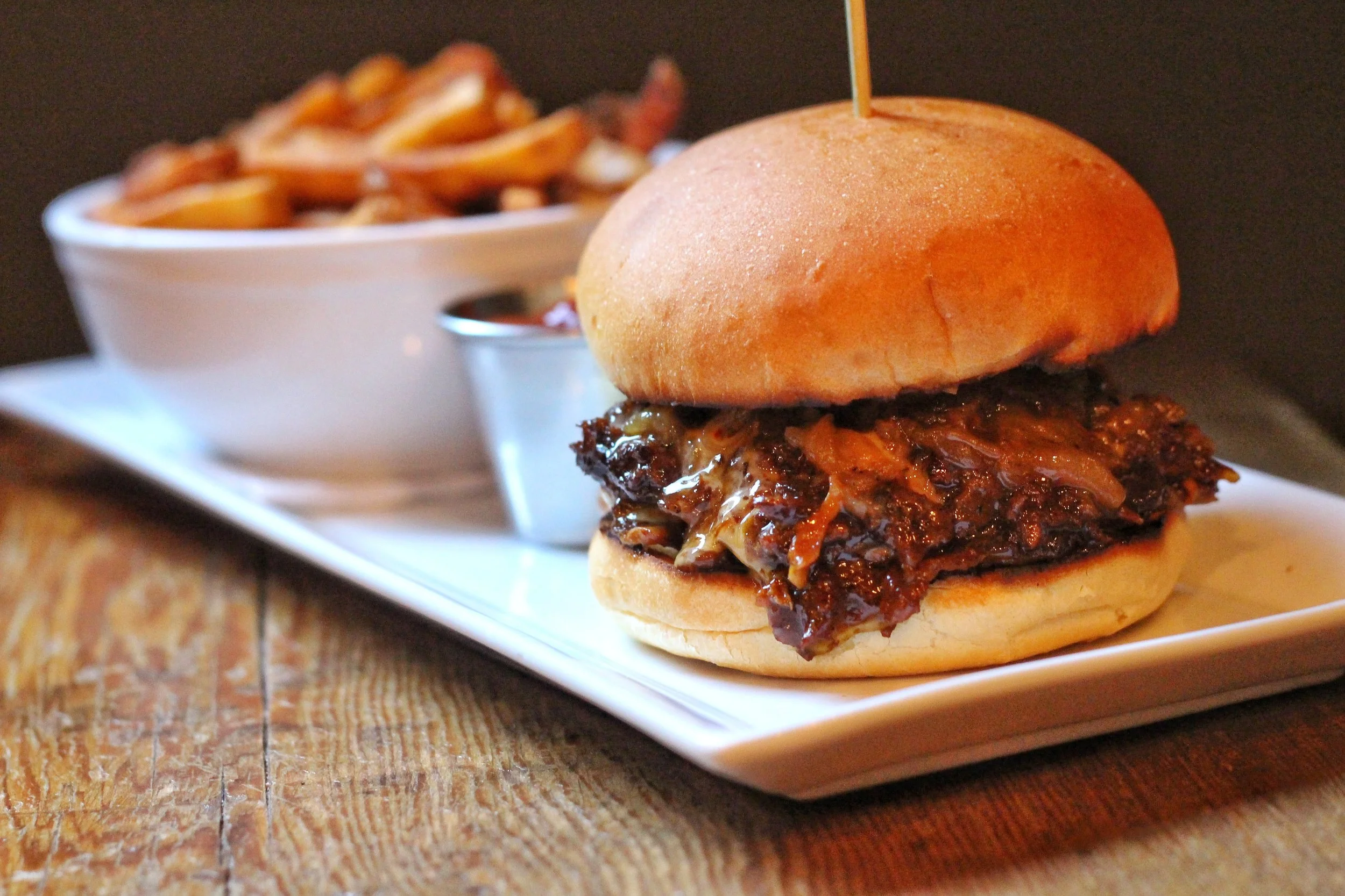 Signature HBH Burger – beef patty, philly meat, beer-braised onions, sweet chili aioli, American white cheese, brioche bun