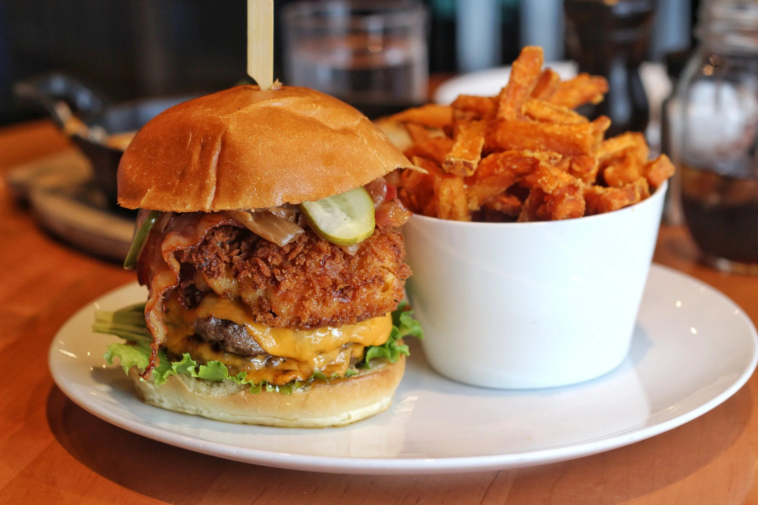 Smash Burger – two beef patties, cheddar cheese, smash sauce, lettuce, pickles, onion chips, brioche bun with added caramelized onion, bacon, mac & cheese cake