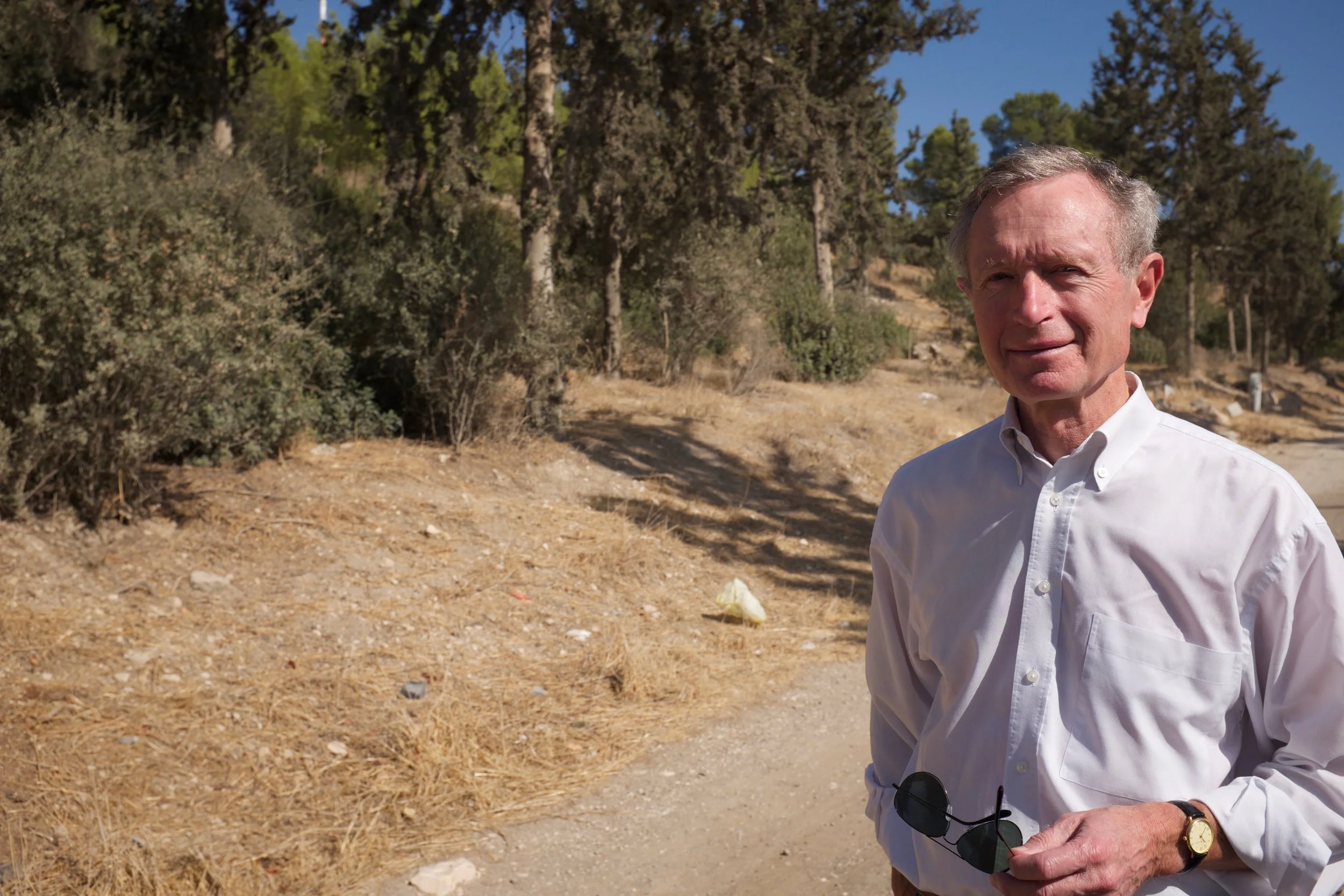 Erik Ader in Bayt Nattif met naaldbomen voor zijn vader geplant door JNF op de achtergrond