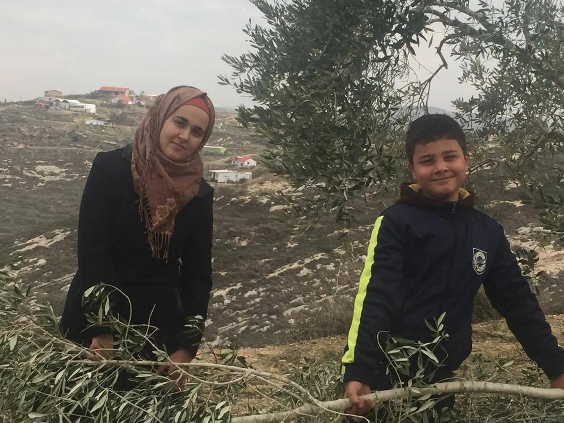 Twee kinderen van Abed Rachman op het land van de familie, met in de achtergrond de outpost Havat Gilad