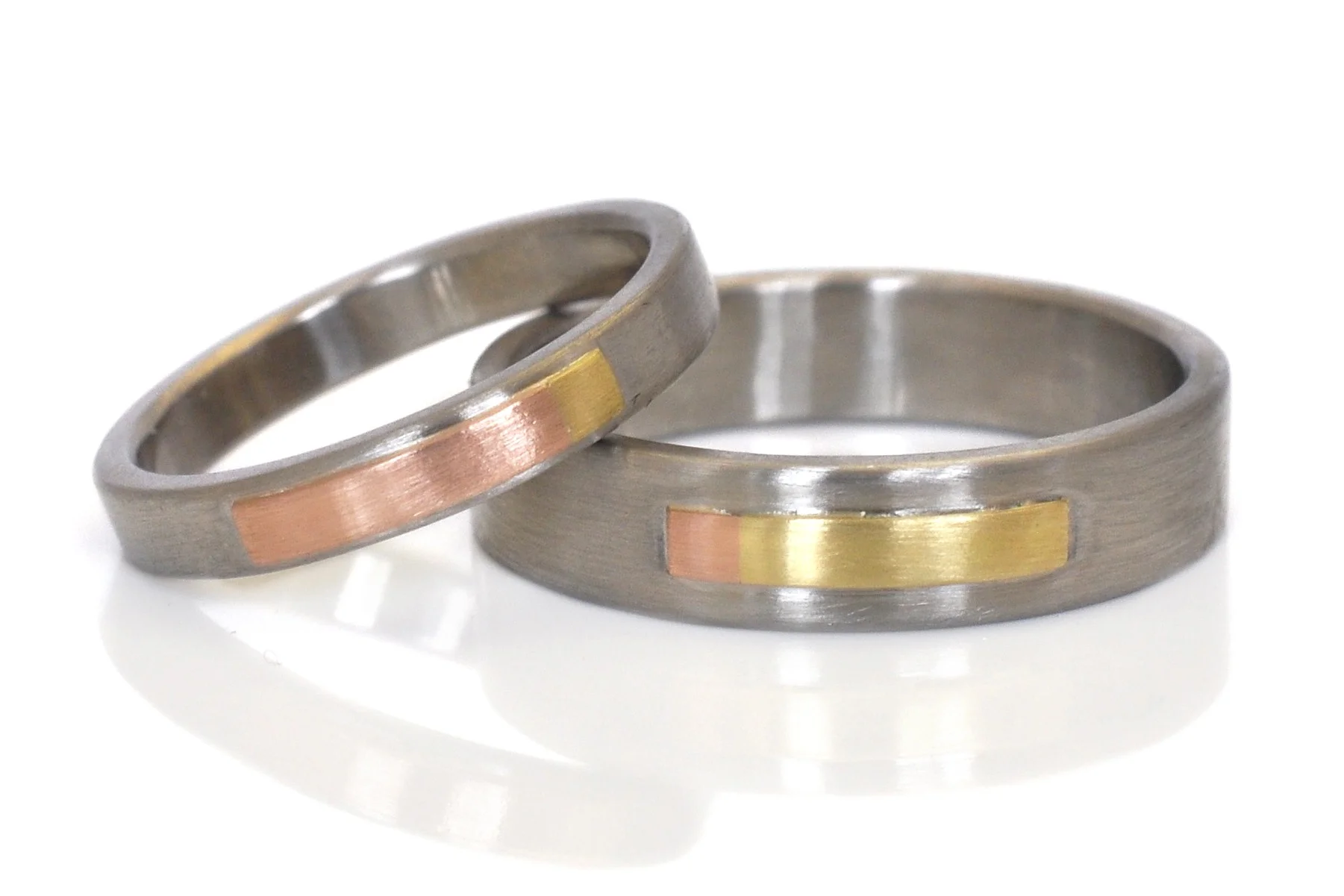 Custom complimentary wedding bands in mixed metals of 500 palladium, 14k red gold and 18k yellow gold with a sleek satin finish. I love the subtle color change at the end of the Rivet strips.