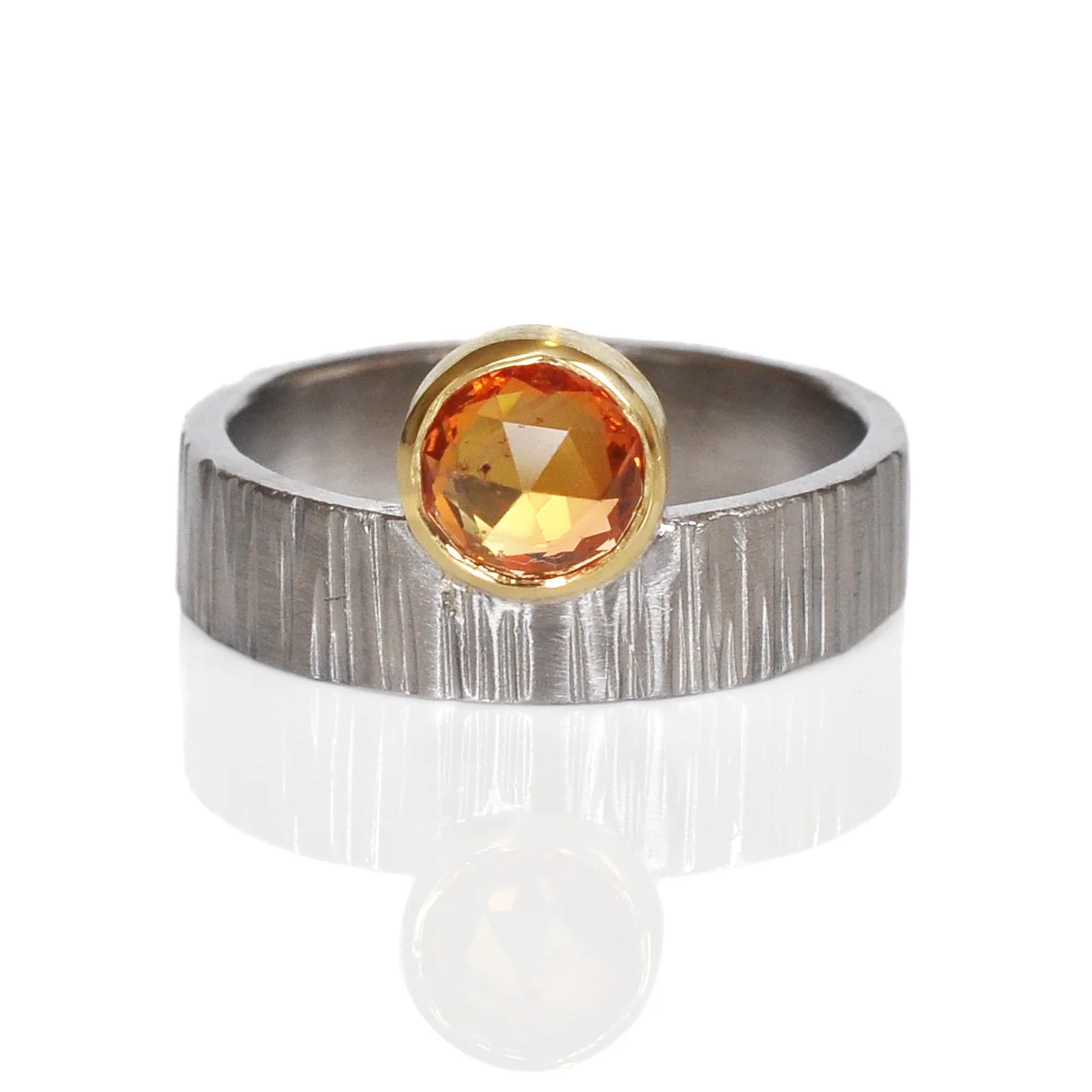 Orange rose cut sapphire in 18k yellow gold off-set on linear hammered 500 palladium.