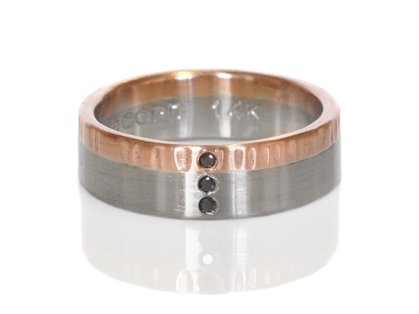 Modern mixed metal wedding band of linear hammered 14k red gold, satin finish 500 palladium and flush set black diamonds.