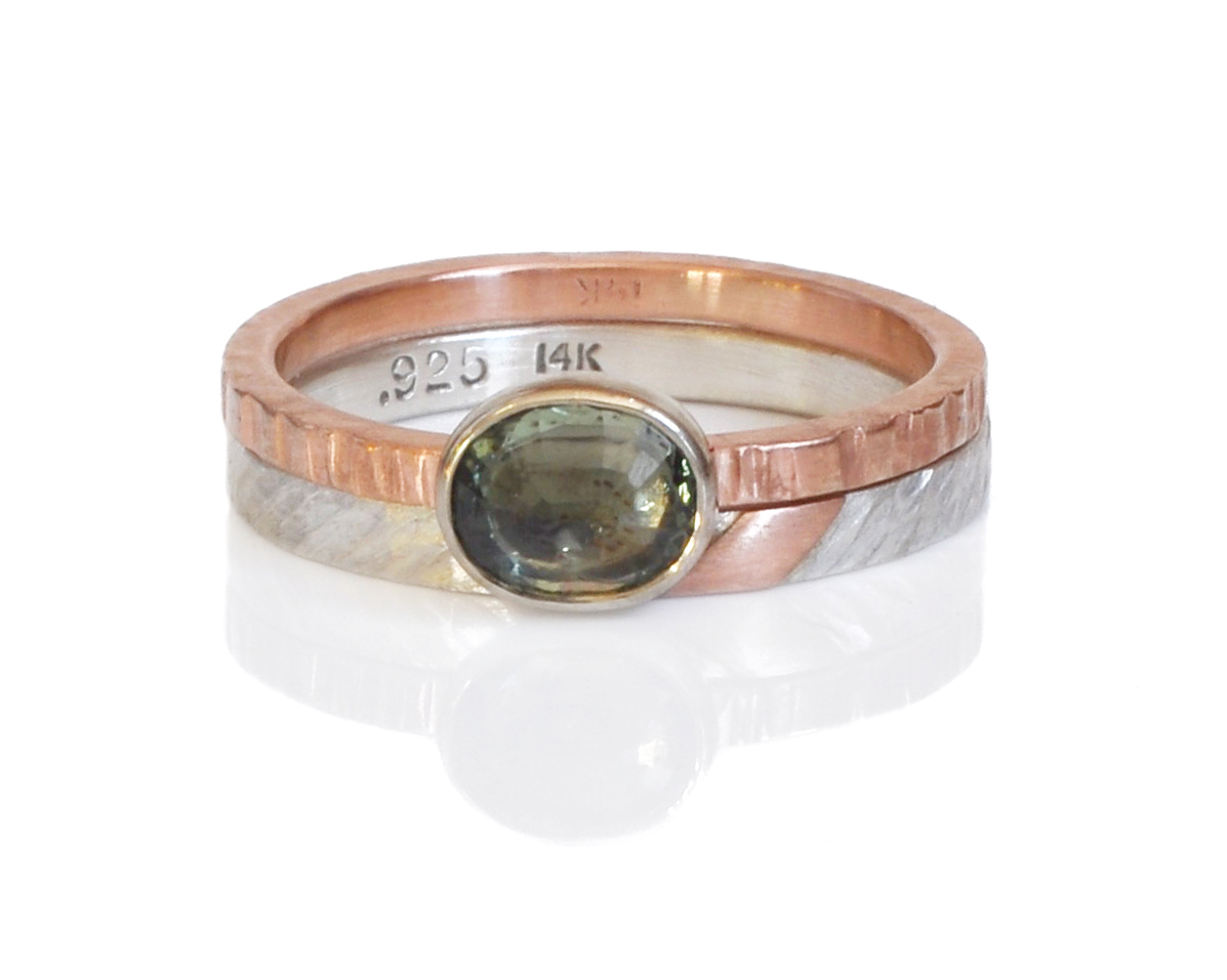 Amy paired this oval green sapphire in mixed metals of 14k red gold and 14k white gold bezel with a modern mixed metal band in diagonal hammered sterling silver with a 14k red gold accent.