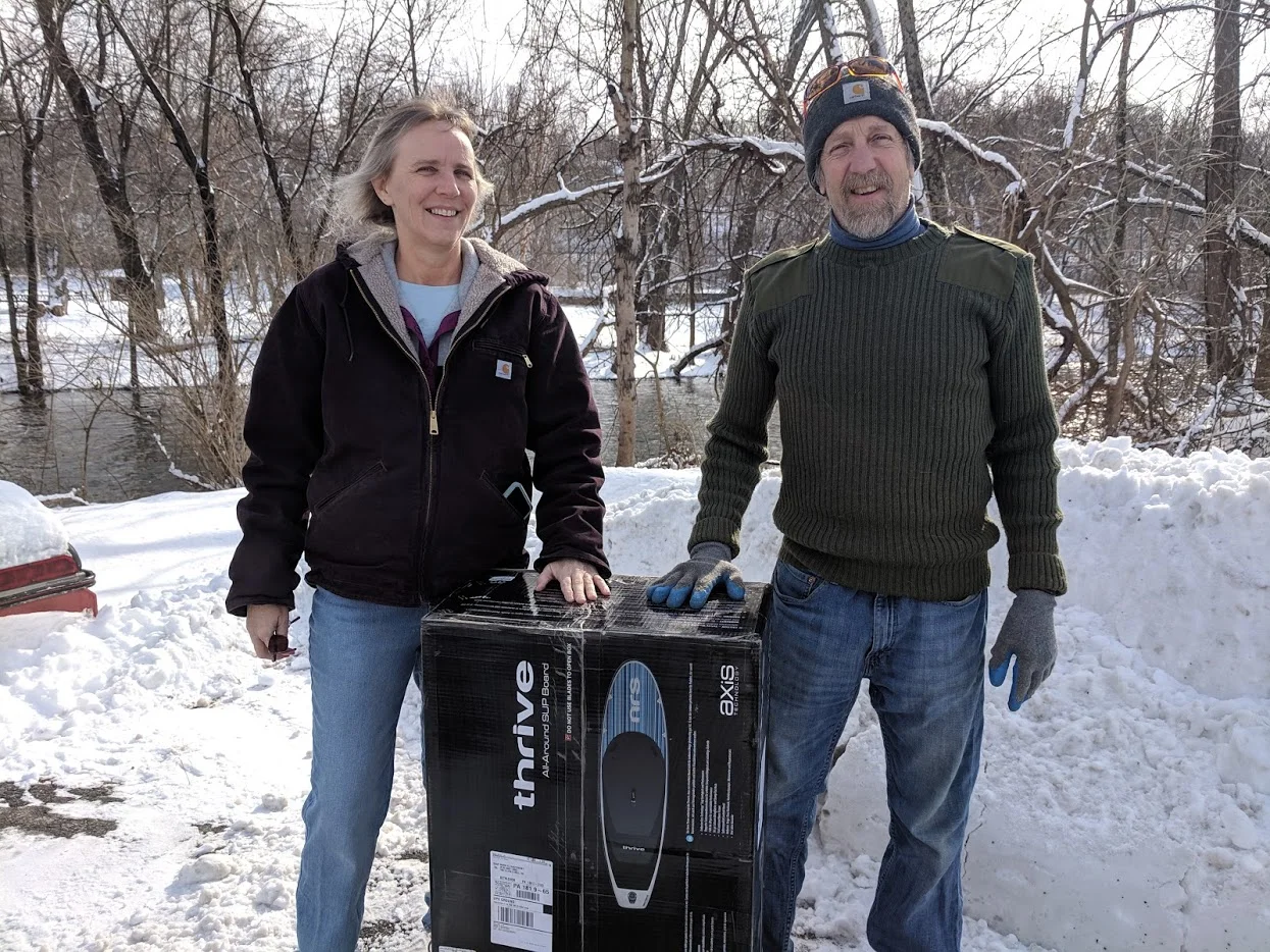 DRM’s final contest winner, Sue, and her husband standing with their prize, a new paddleboat.