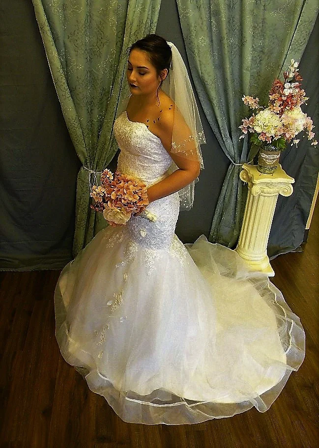  This beautiful mermaid is fully beaded. The hemline is a horsehair edge. Horsehair edges are usually 2" wide and are a bit stiff, making them hold their shape well. Here she is wearing a tulle veil without embellishments. This dress would look amazi