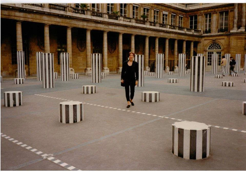 Susan Manno at the Palais Royal, Paris, amid Daniel Buren’s installation, “Les Deux Plateaux,” 1985-86. Photo by Alexander Wood.