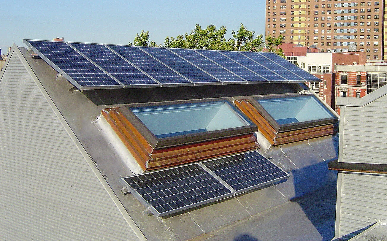Paul A. Castrucci, Architects - 179 Rivington St building is Passive House. Image features rooftop solar panels and Lower East Side cityscape.