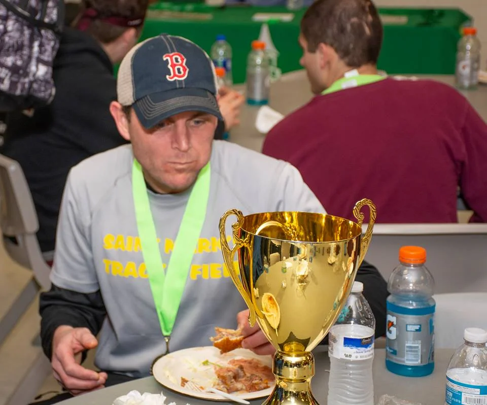 3rd Annual MMF Delaware Run for Strength 5k Champion, Michael DiGennaro, refuels while admiring the MMF Joseph Williams Champion Trophy.
